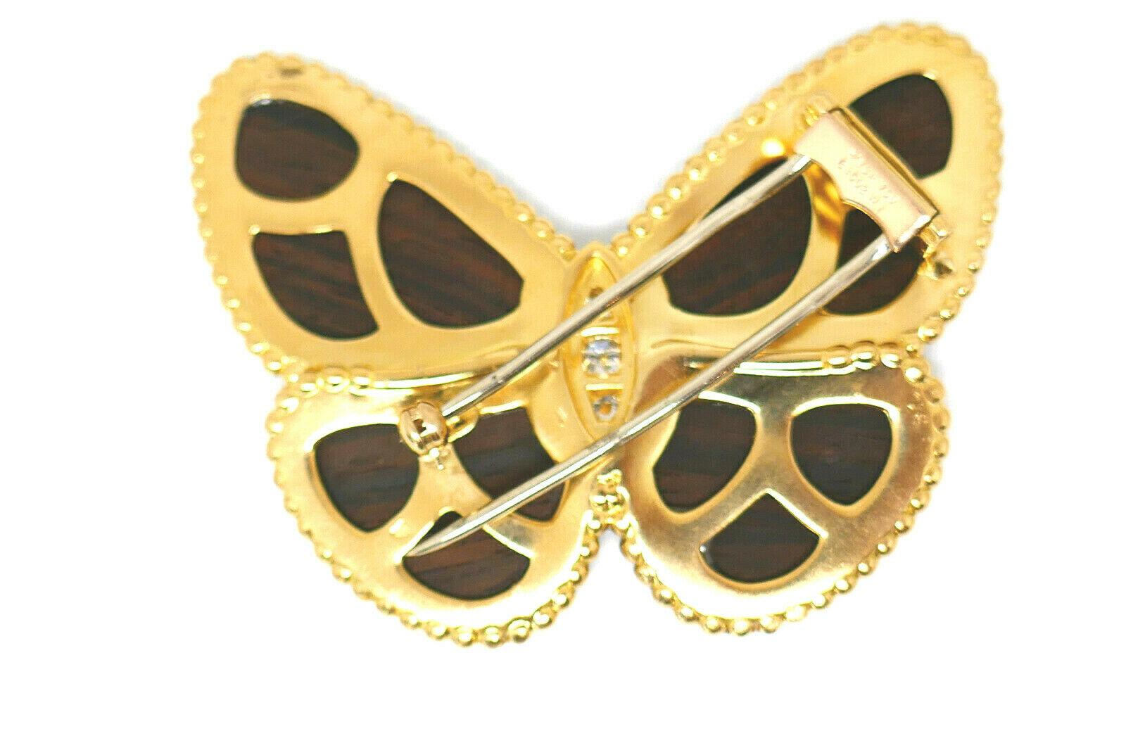 Iconic design from Van Cleef & Arpels. Wooden wings placed within a polished gold trim. Features three brilliant cut diamonds, total weight is about 0.30 ct.
Stamped with the VCA  maker's mark, a hallmark for 18k gold and a serial number.