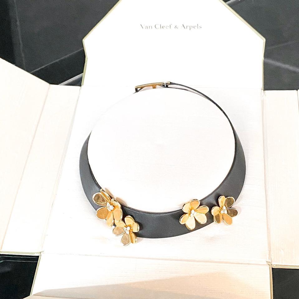 This fabulous Van Cleef & Arpels choker necklace from the iconic Frivole collection is made in black patent leather and beautifully mounted with graduated 18k yellow gold flowers prong-set with X brilliant-cut round E-F VVS1-VVS2 diamonds of an