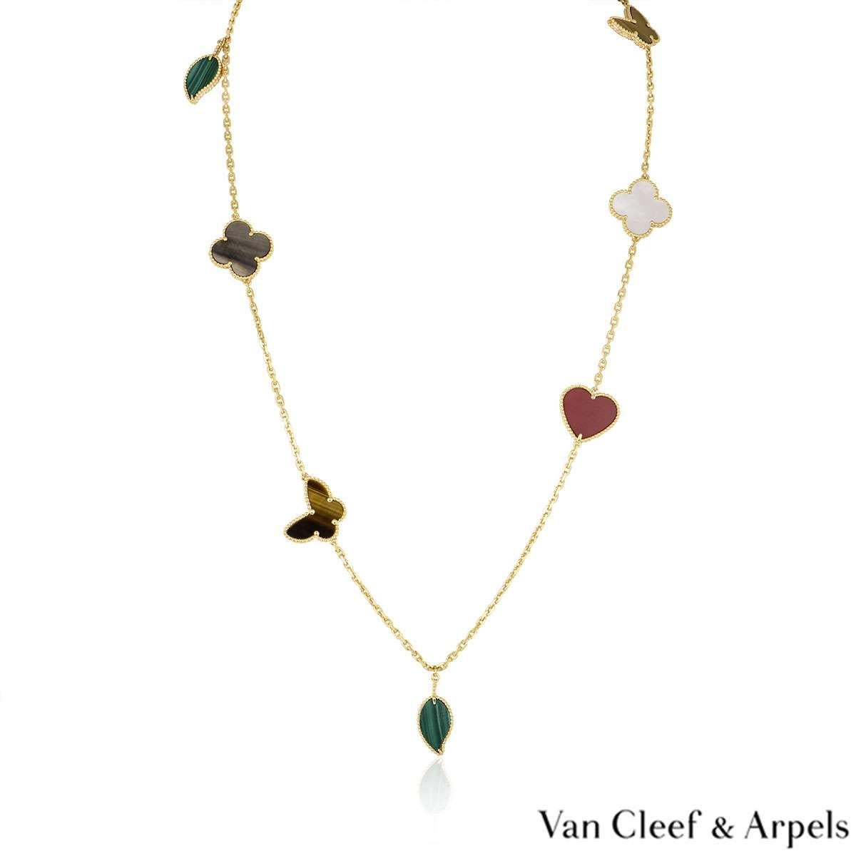 A beautiful 18k yellow gold Lucky Alhambra long necklace by Van Cleef & Arpels. The necklace features 12 motifs, with a mixture of symbols such as hearts, butterflies, leaves and clovers. The motifs are set with carnelian, tiger's eye, white & grey