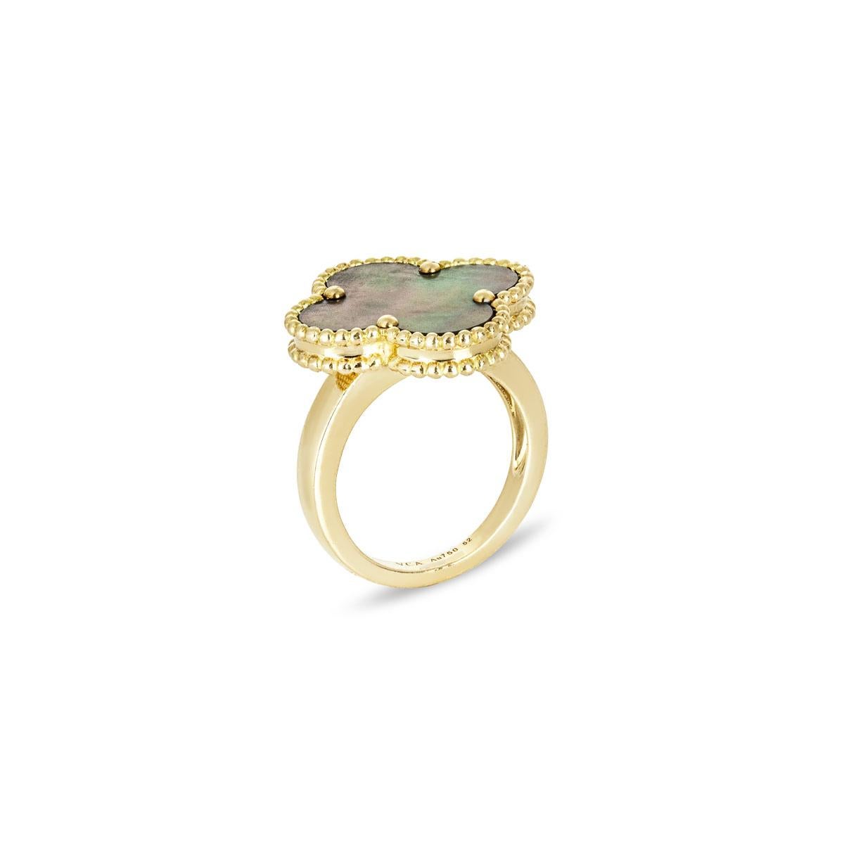 An 18k yellow gold grey mother of pearl ring by Van Cleef & Arpels from the Magic Alhambra collection. The ring features the iconic 4-leaf clover motif with a grey mother of pearl inlay, complemented by the iconic beaded edge. The ring is a size M