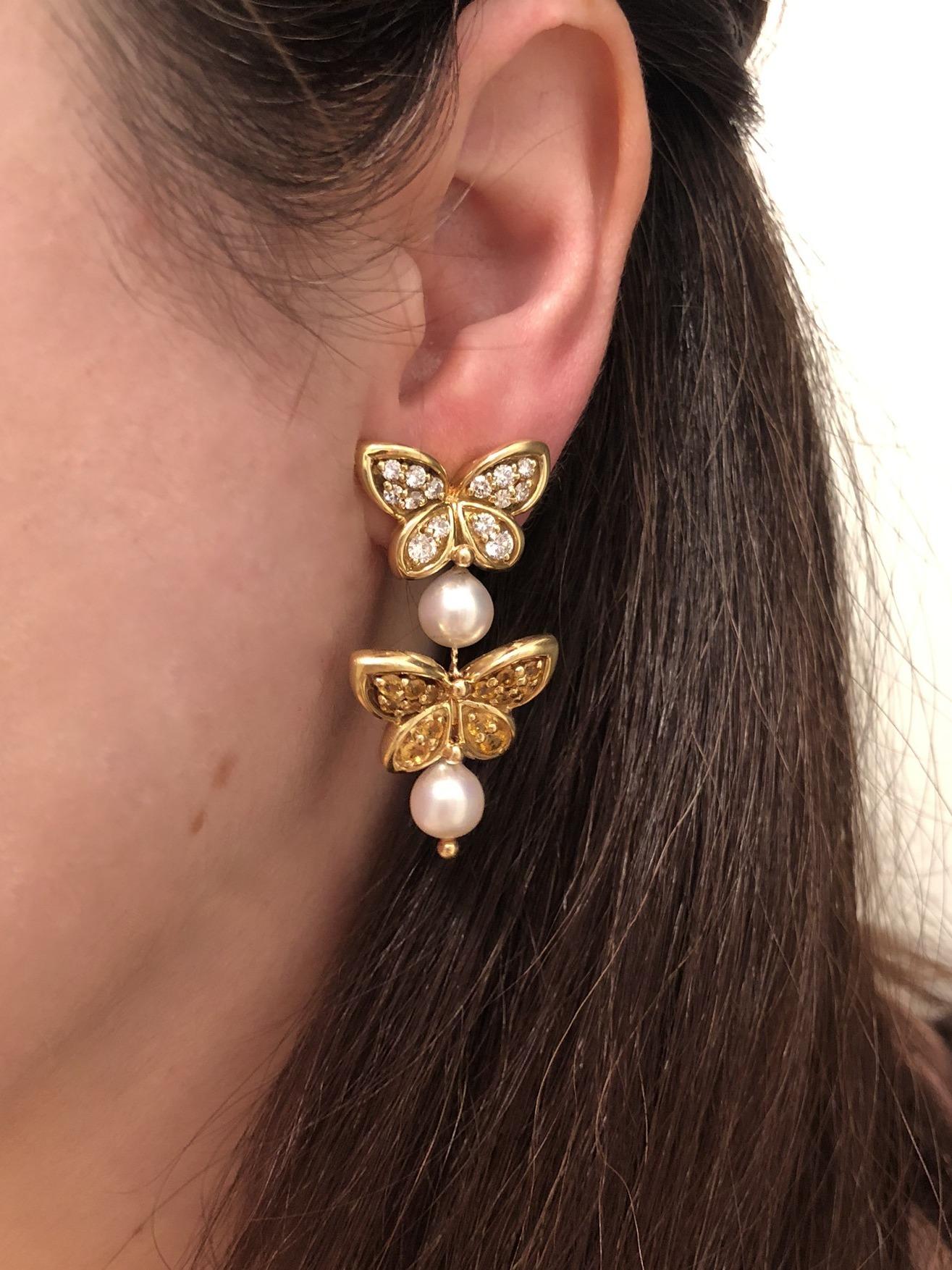 These Van Cleef & Arpels 18K yellow gold earrings of a butterfly motif have 28 diamonds, totaling approximately 1.70 carats, and 28 yellow sapphires totaling approximately 3 carats, and 4 cultured pearls. The last year of production for this model
