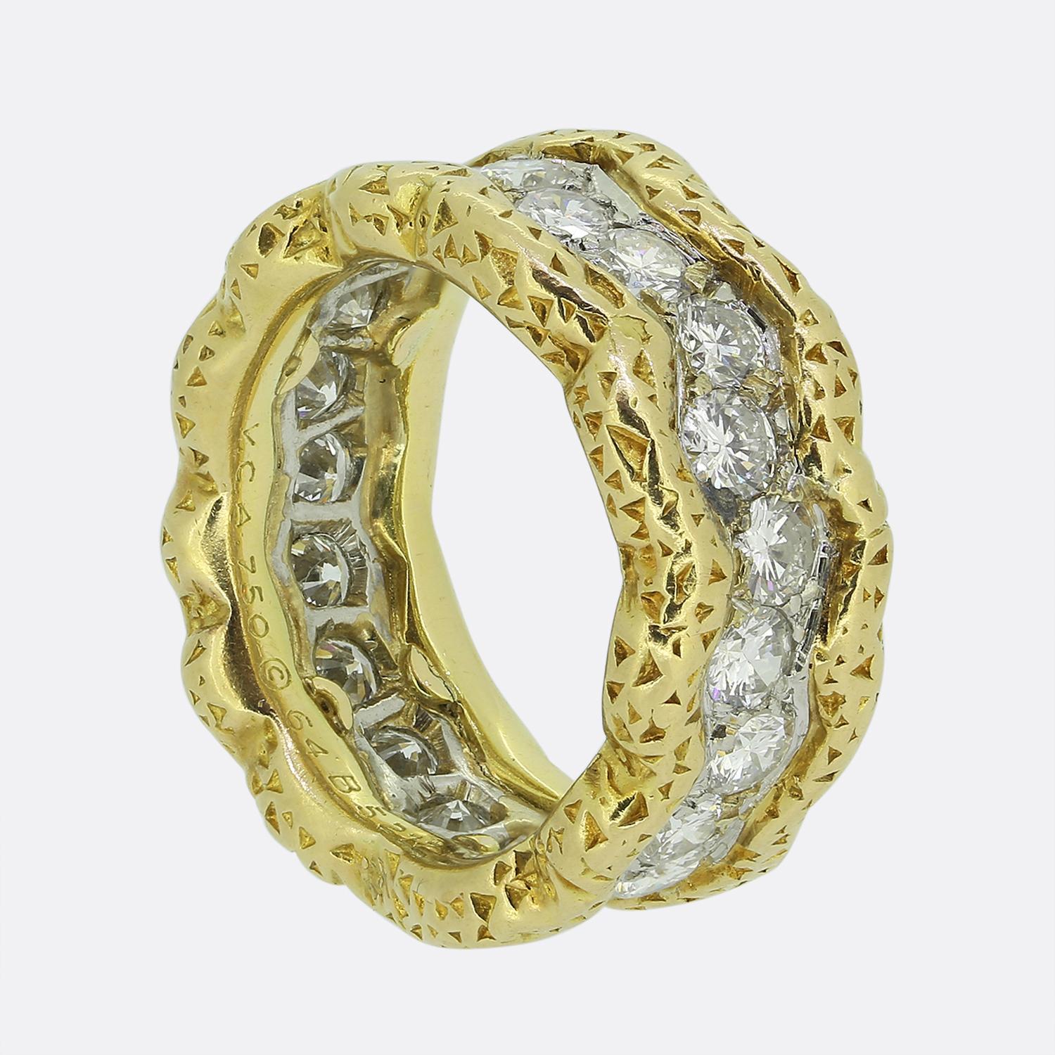 Here we have a captivating eternity ring from renowned jewellery designer Van Cleef & Arples. A rich 18ct yellow gold undulating border has been ornately engraved with a sporadic triangular pattern whilst playing host to a single row of bright white