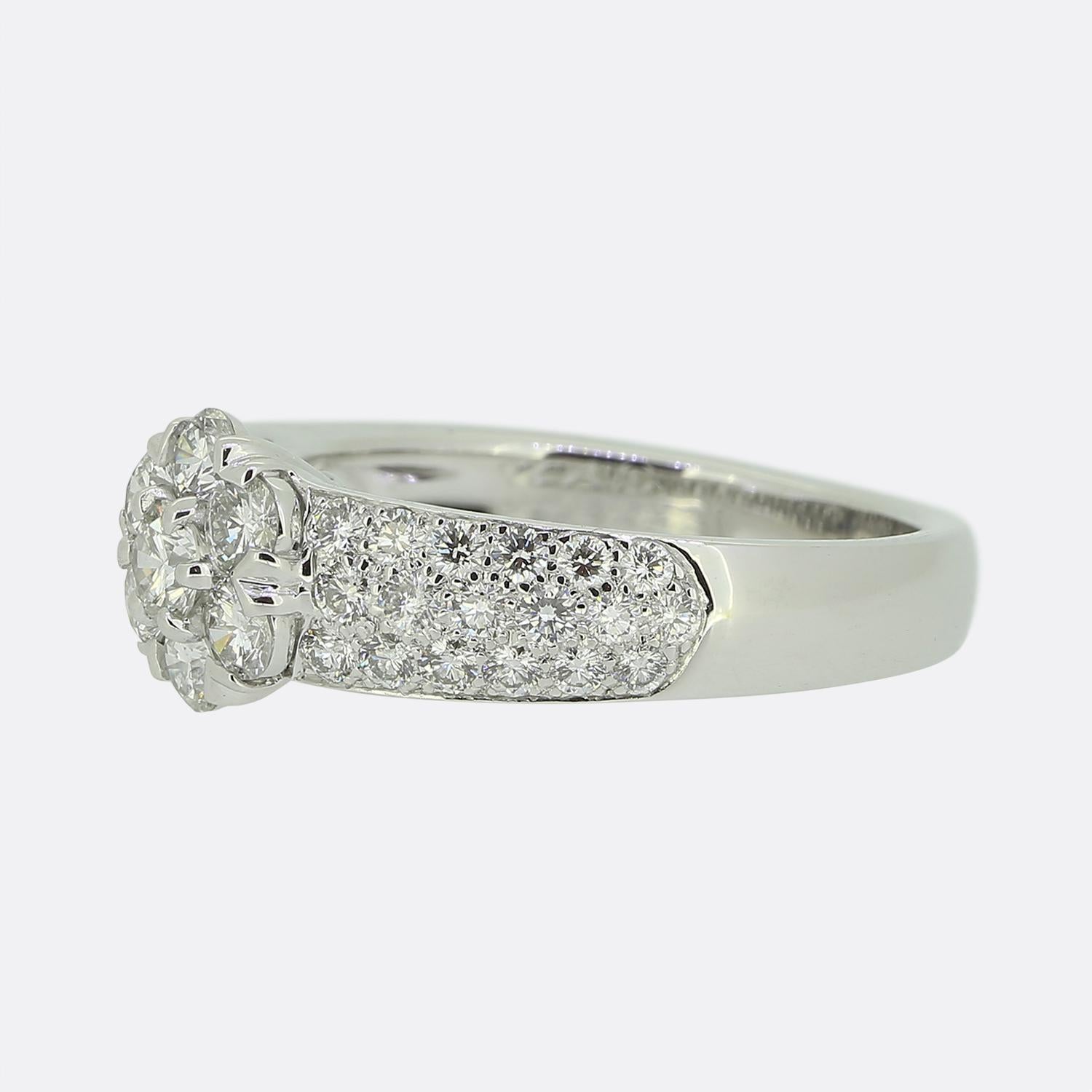 Hier haben wir einen bezaubernden Diamant-Cluster-Ring des weltbekannten Schmuckdesigners Van Cleef & Arpels, der Teil ihrer Fleuette-Kollektion ist. Dieses Schmuckstück wurde aus 18 Karat Weißgold gefertigt und zeigt in der Mitte ein florales