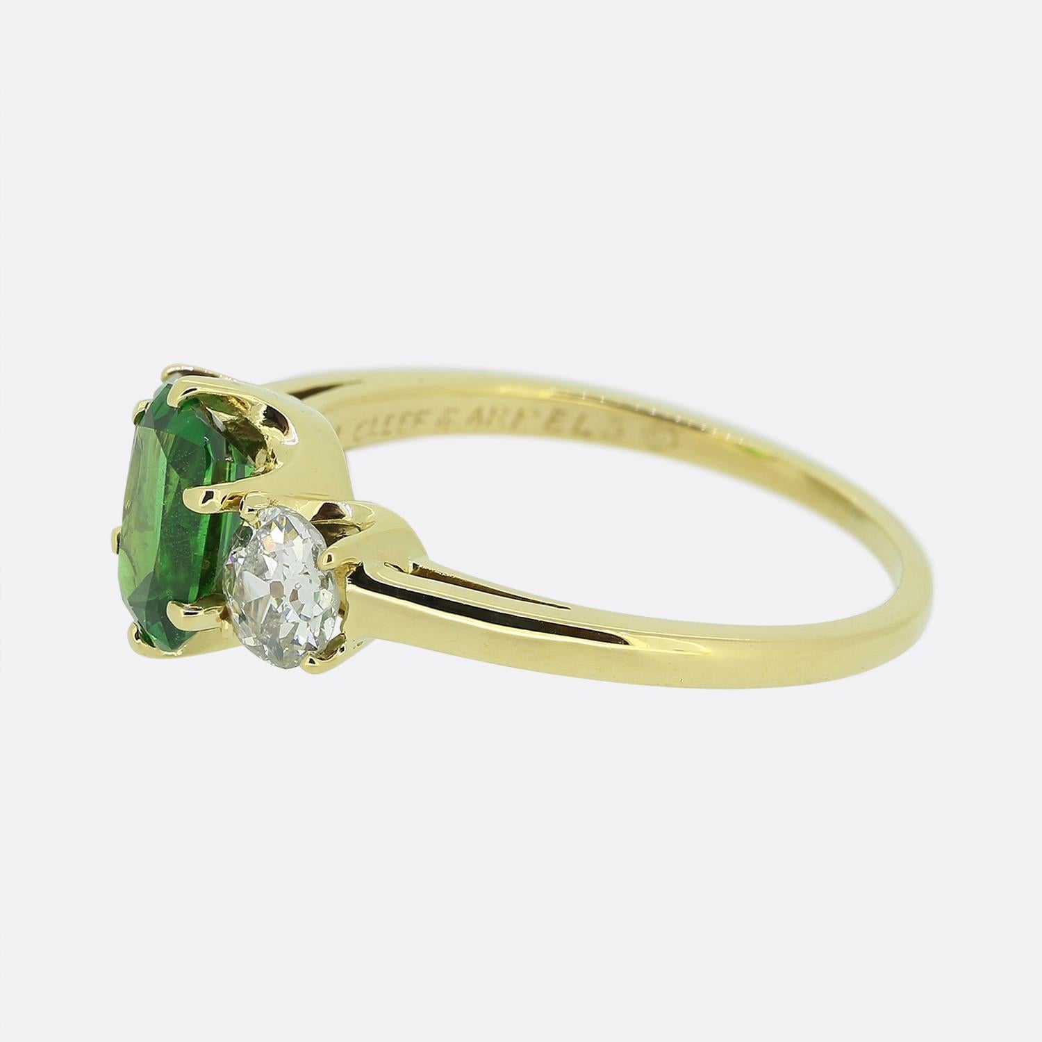 Here we have an outstanding creation from the world renowned luxury jewellery designer Van Cleef & Arpels. This ring has been crafted from 18ct yellow gold and showcases a trio of gemstones across the face. A single oval faceted tsavorite garnet