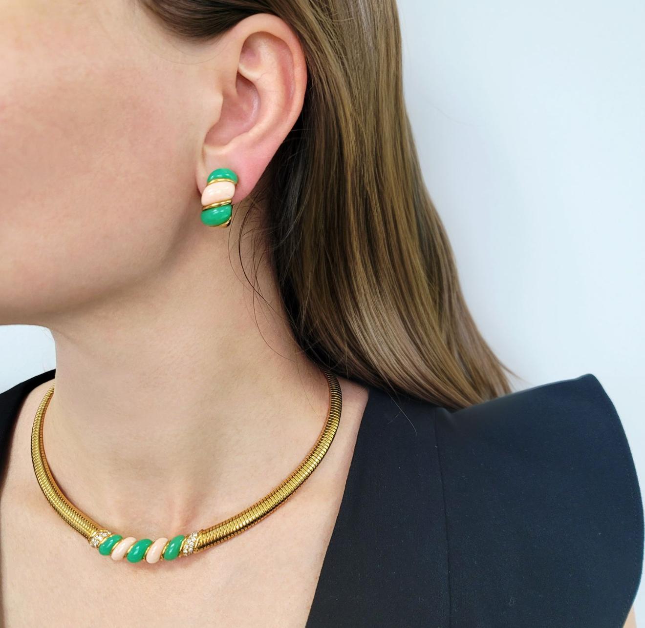 Suite di collana e orecchini Van Cleef in crisoprasio, corallo e diamanti.La collana
La catena è a maglie omega, con al centro pannelli di corallo pelle d'angelo e crisoprasio, affiancati da due sezioni con diamanti; in totale ci sono 24 diamanti