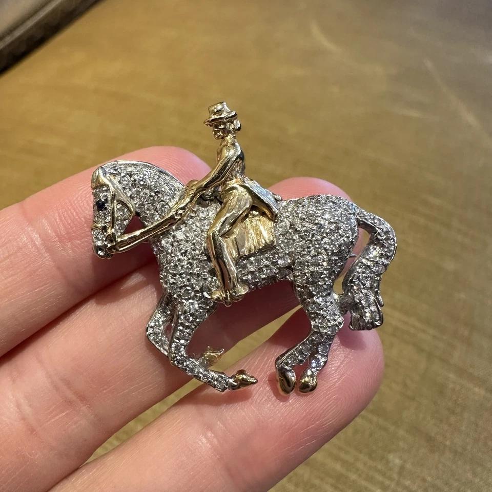 VAN DELL Diamond Pave Horse and Rider Pin / Pendant in 14k White and Yellow Gold

Diamond Pave Horse and Lady Rider Pin feature Round Brilliant Diamonds Pave in 14k White Gold with an 14k Yellow Gold Lady rider and saddle. The piece has a single bar