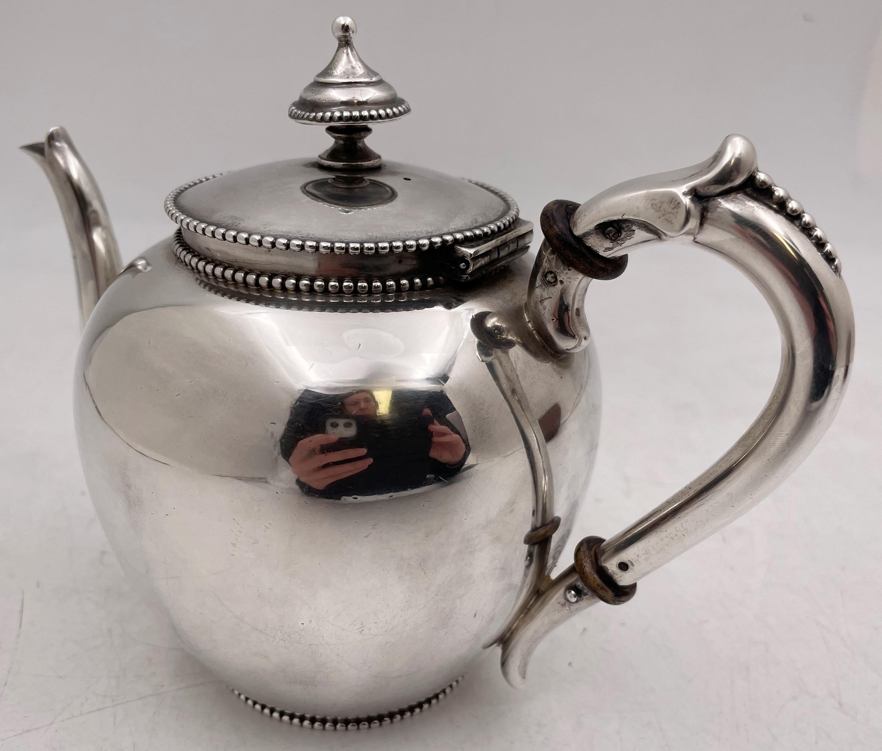 J. M. Van Kempen, Dutch continental silver teapot from the 19th century, with beaded motifs adorning the rim, base, and handle, and with an elegant design. It measures 5 3/4'' in height by 7 5/8'' from handle to spout by 4 3/8'' in depth, weighs