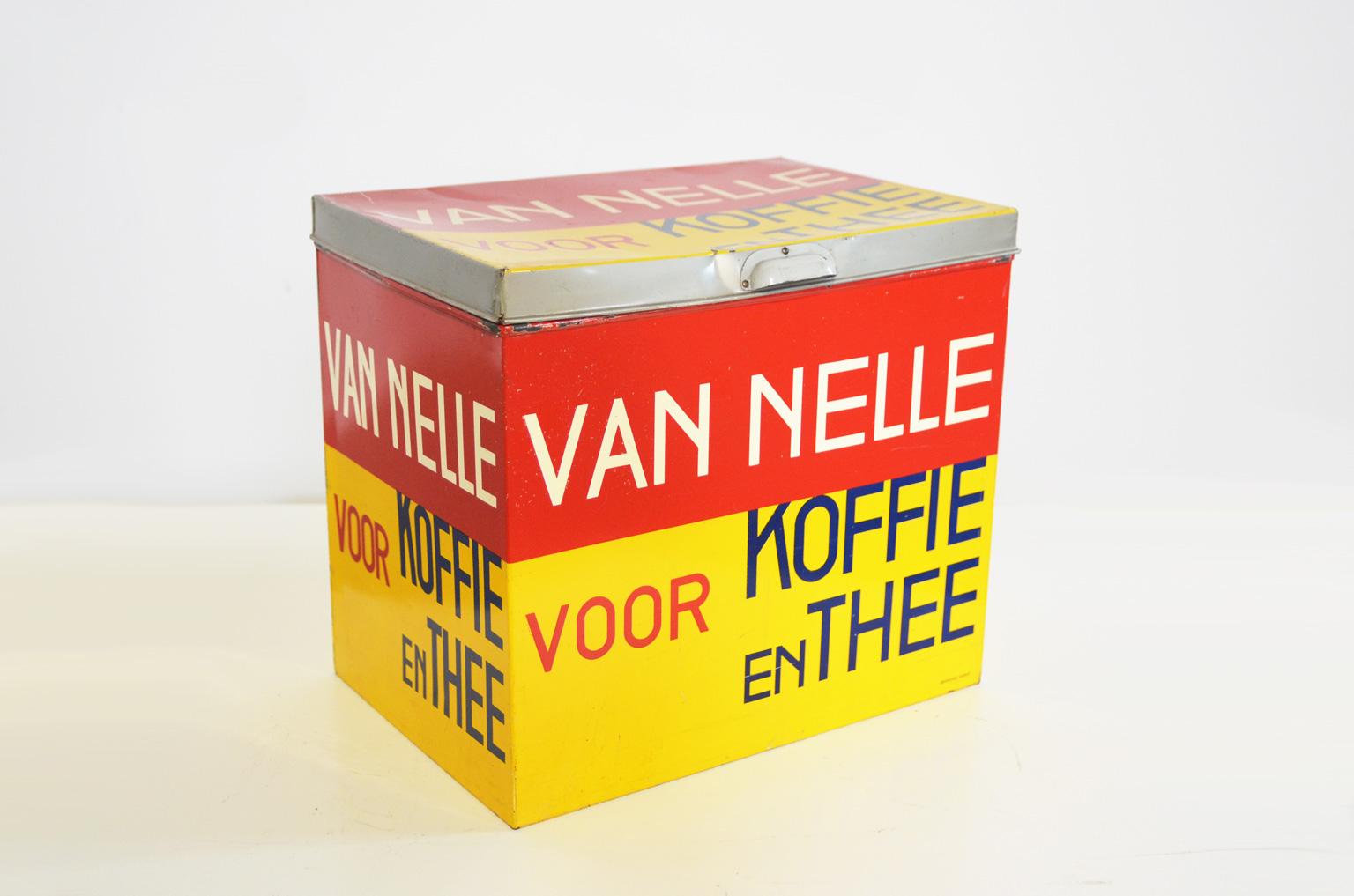 Rectangular, tall tin with lid, painted in a bright yellow and red lane. On each side and on the lid the same text in tight, sans serif letters is applied in the colors red, blue and white. The design was strongly influenced by the then-current De