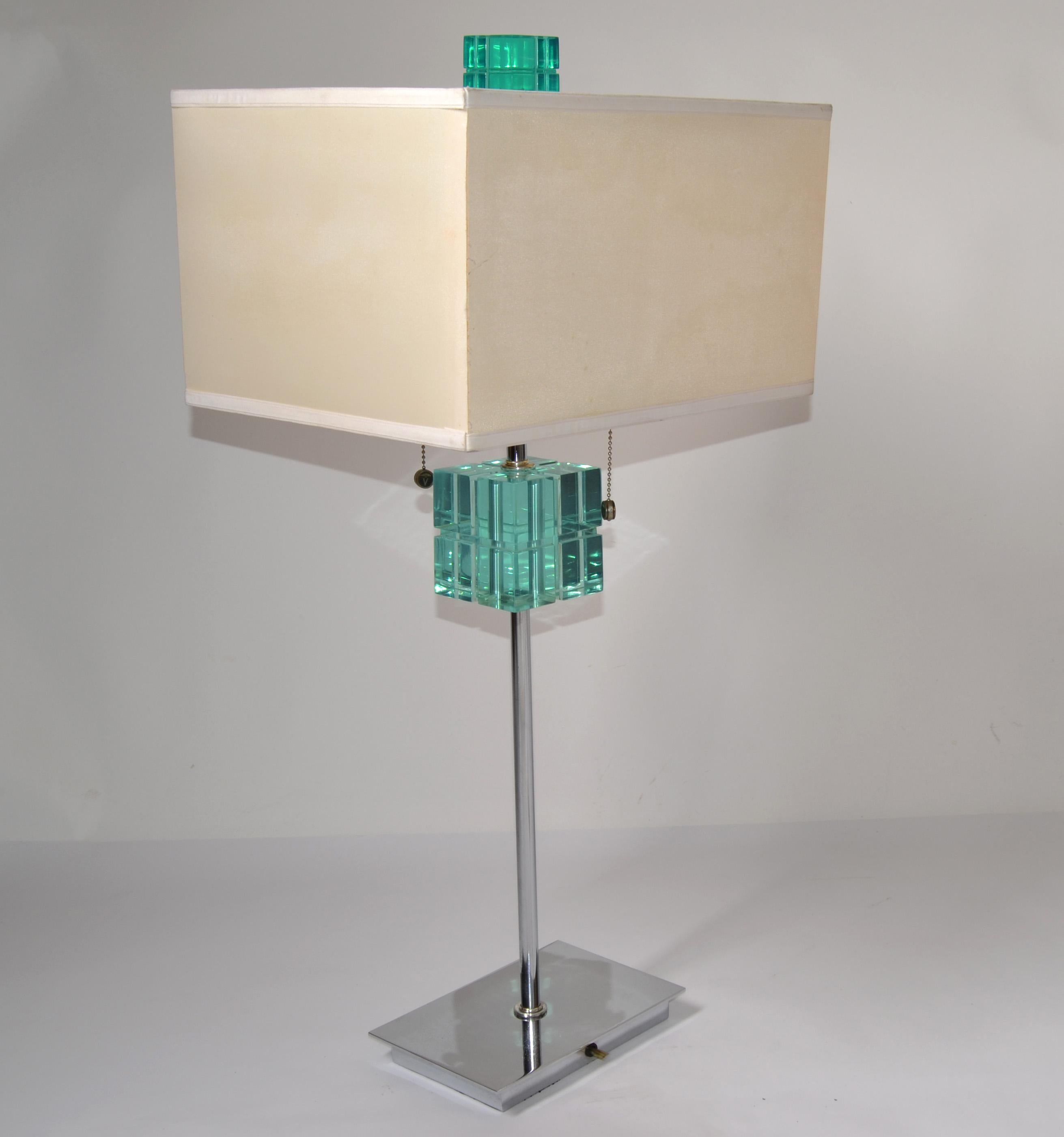 Hivo Van Teal Mid-Century Modern transparente smaragdgrüne Lucite und Chrom Tischlampe mit Rechteck beige Stoff Schatten.
Nickel-Beschläge mit S-Doppel-Cluster-Steckdosen und Zugschnüren. US-verdrahtet, UL-gelistet und in funktionstüchtigem