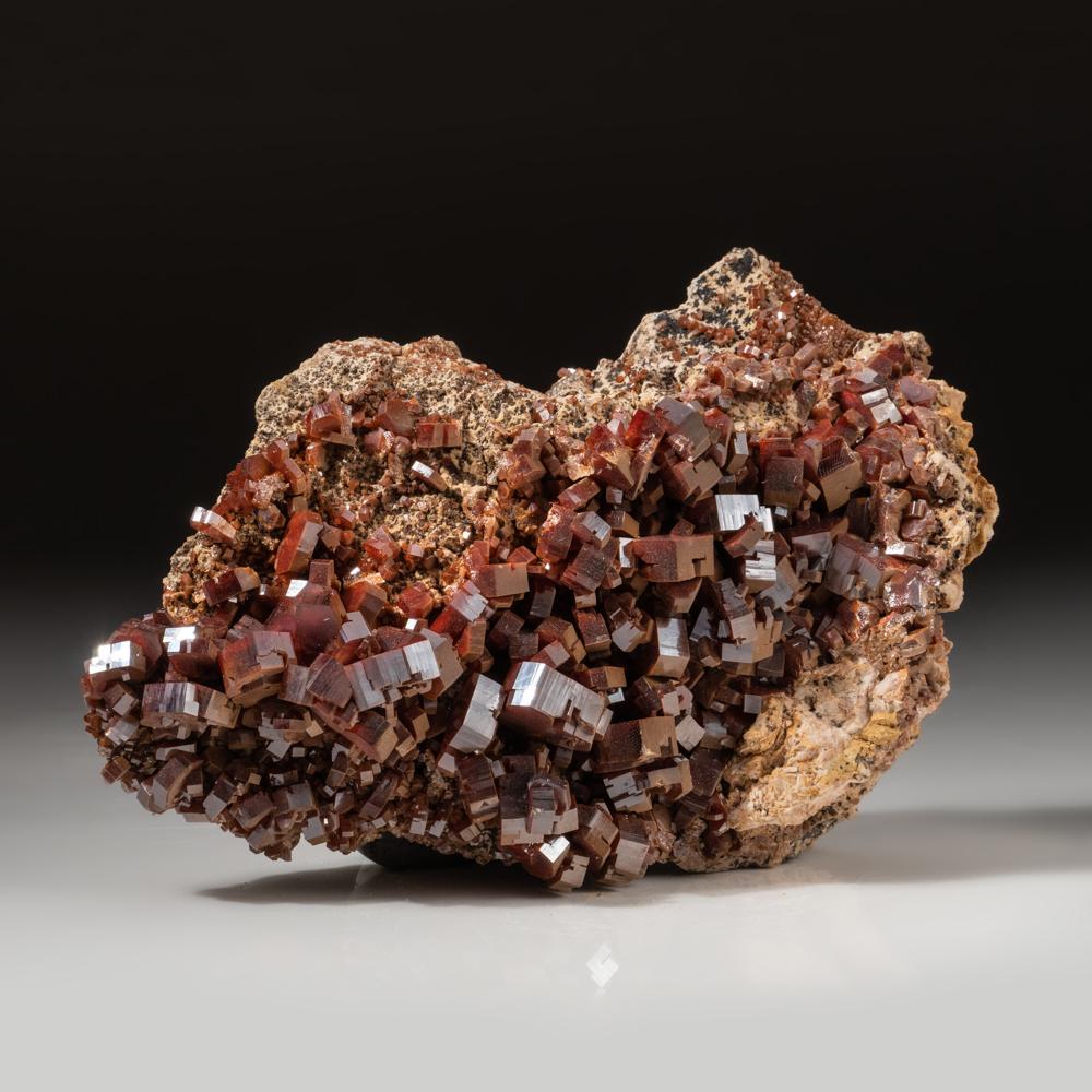 From Mibladen, Atlas Mountains, Khénifra Province, Morocco 

Here is an exceptional world class specimen of a cluster of hexagonal crystals of dark red Vanadinites with glassy luster on barite matrix. The vanadinite crystals are prismatic