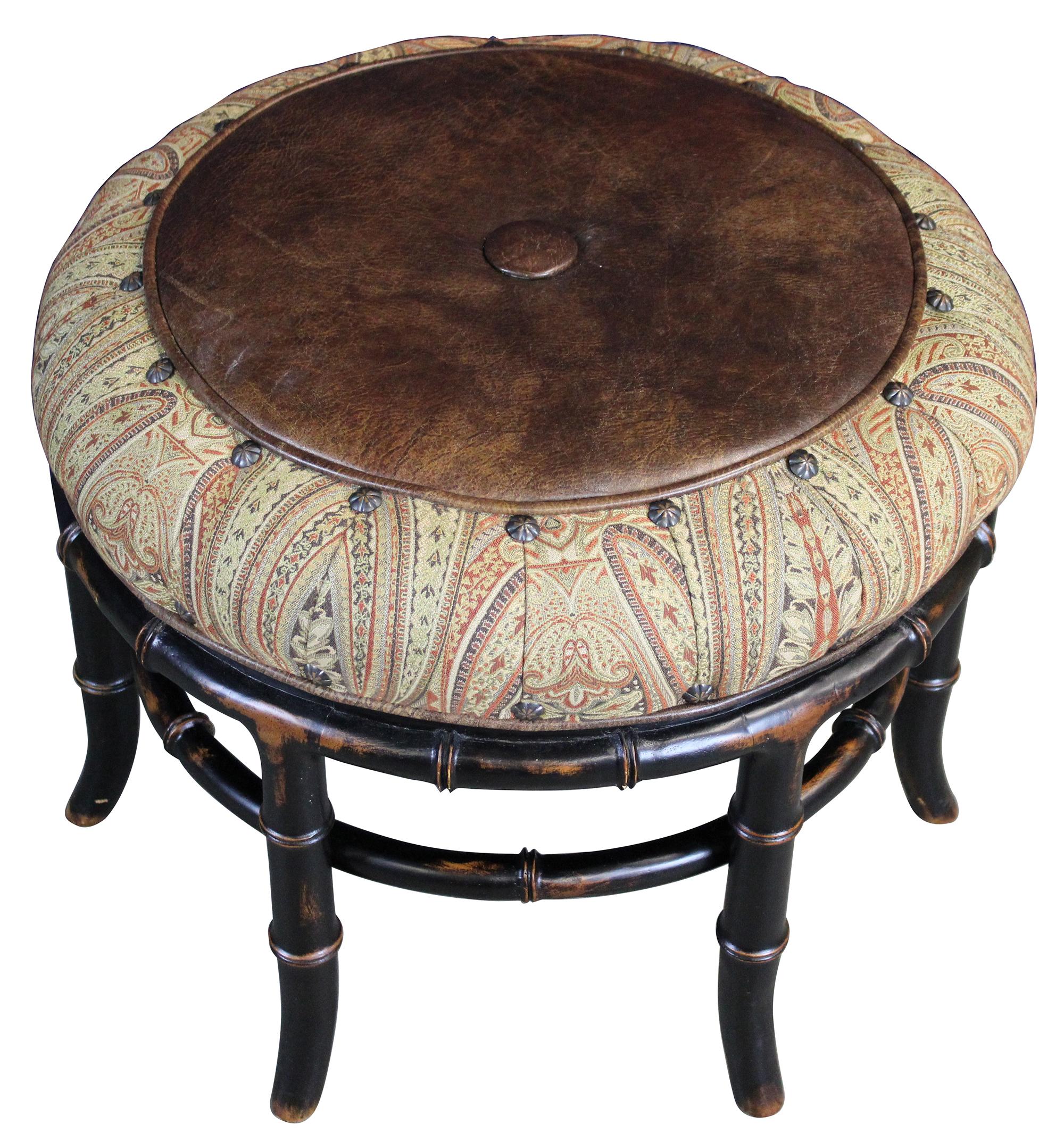 A stunning footstool or bench by Vanguard Furniture. Features a brown leather and paisley upholstered seat with nailhead trim. Supported by lacquered and naturally distressed faux bamboo base. Measures: 30