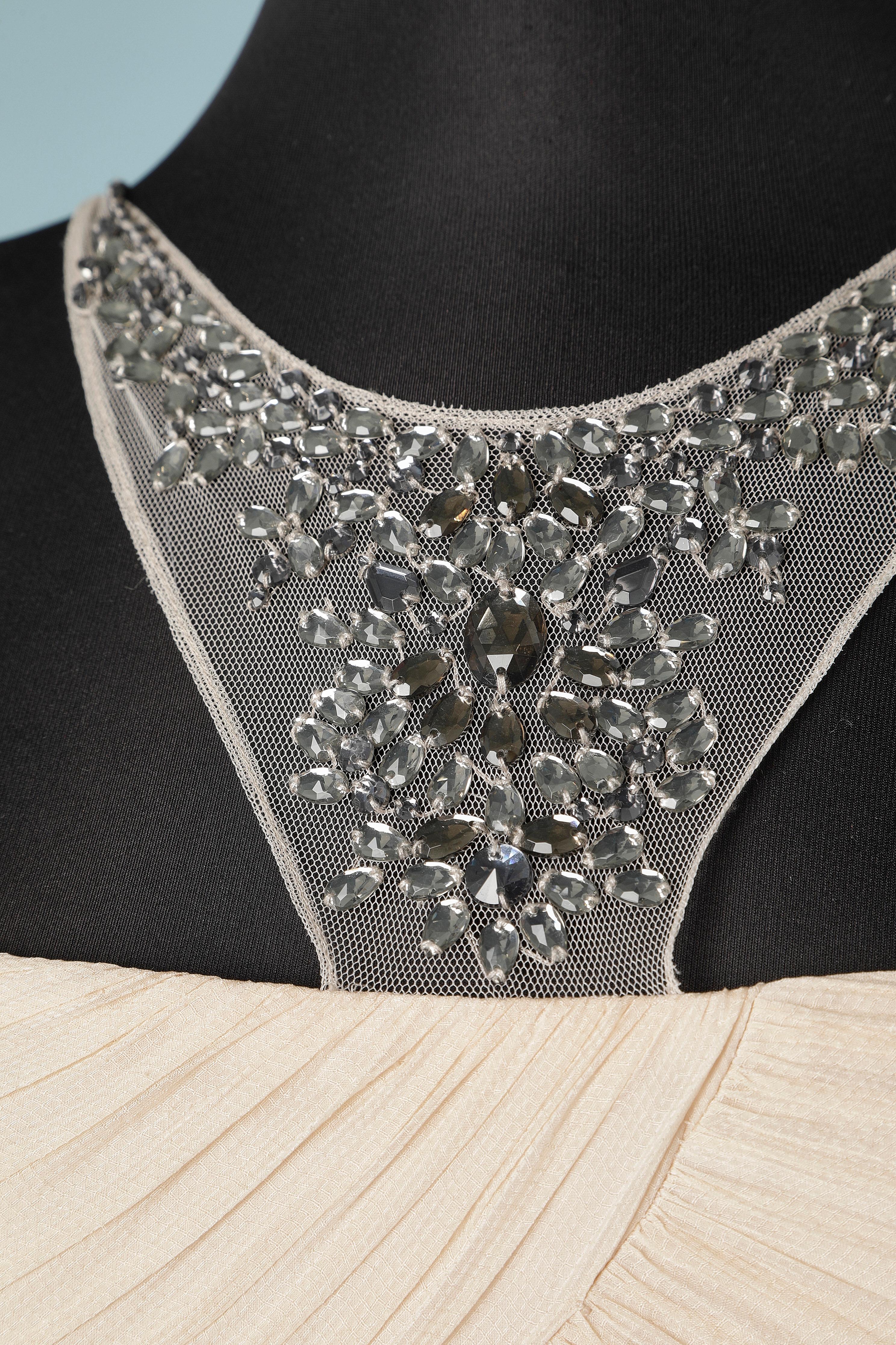 Vanilla silk chiffon cocktail dress with rhinestone embellishment. 
Contrast composition ( tulle) : 100% polyester. Lining composition: 97% polyester, 3% elastane. 
Boned bustier inside the bust with Silicone strap inside on the edge . Adjustable
