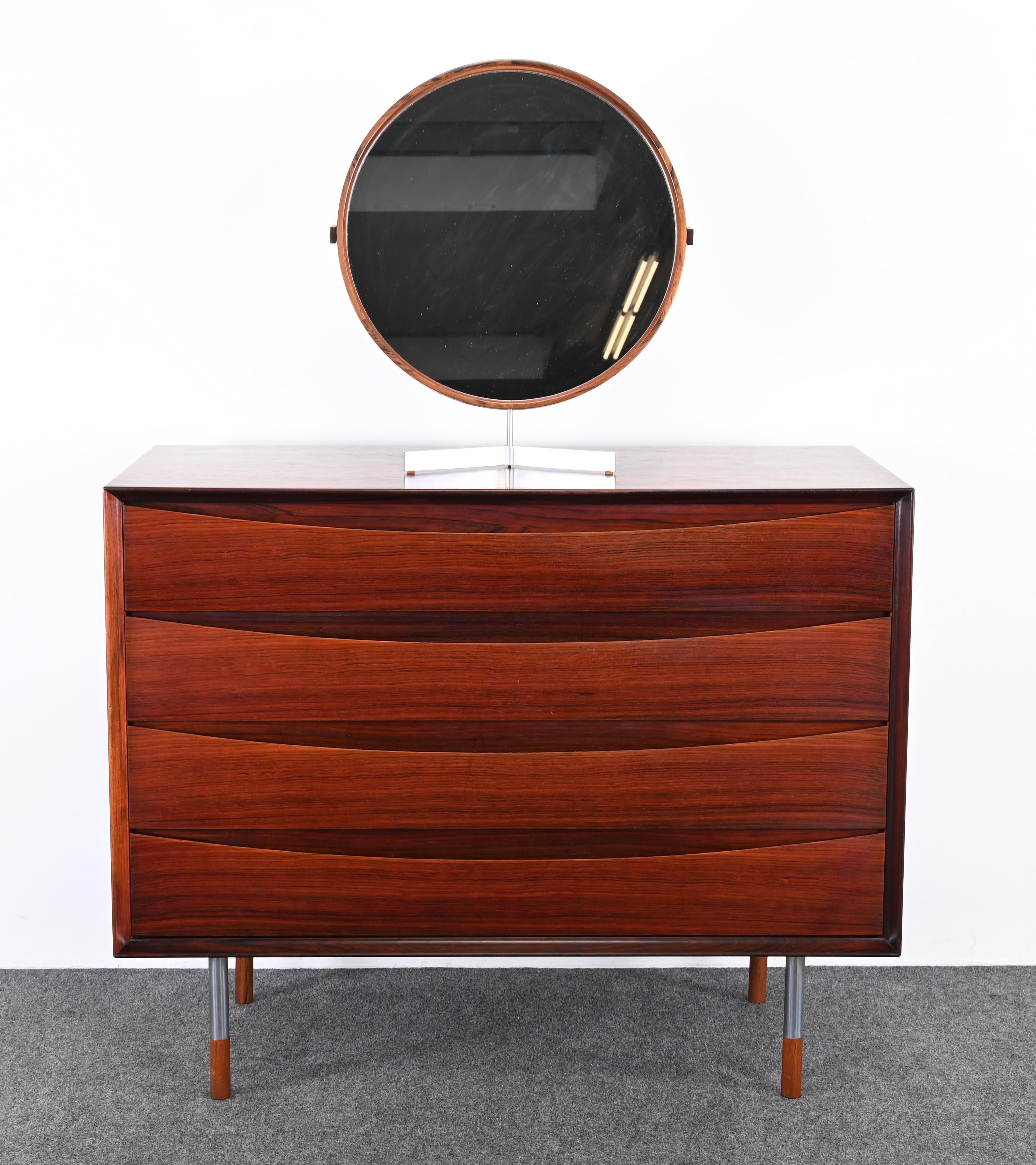 An elegant Uno & Östen Kristiansson Mirror Produced by Luxus in Vittsjö, Sweden. This beautiful rosewood mirror has great design and scale. It would look great on a vanity or chest, as shown in the images. The steel and rosewood mirror would look