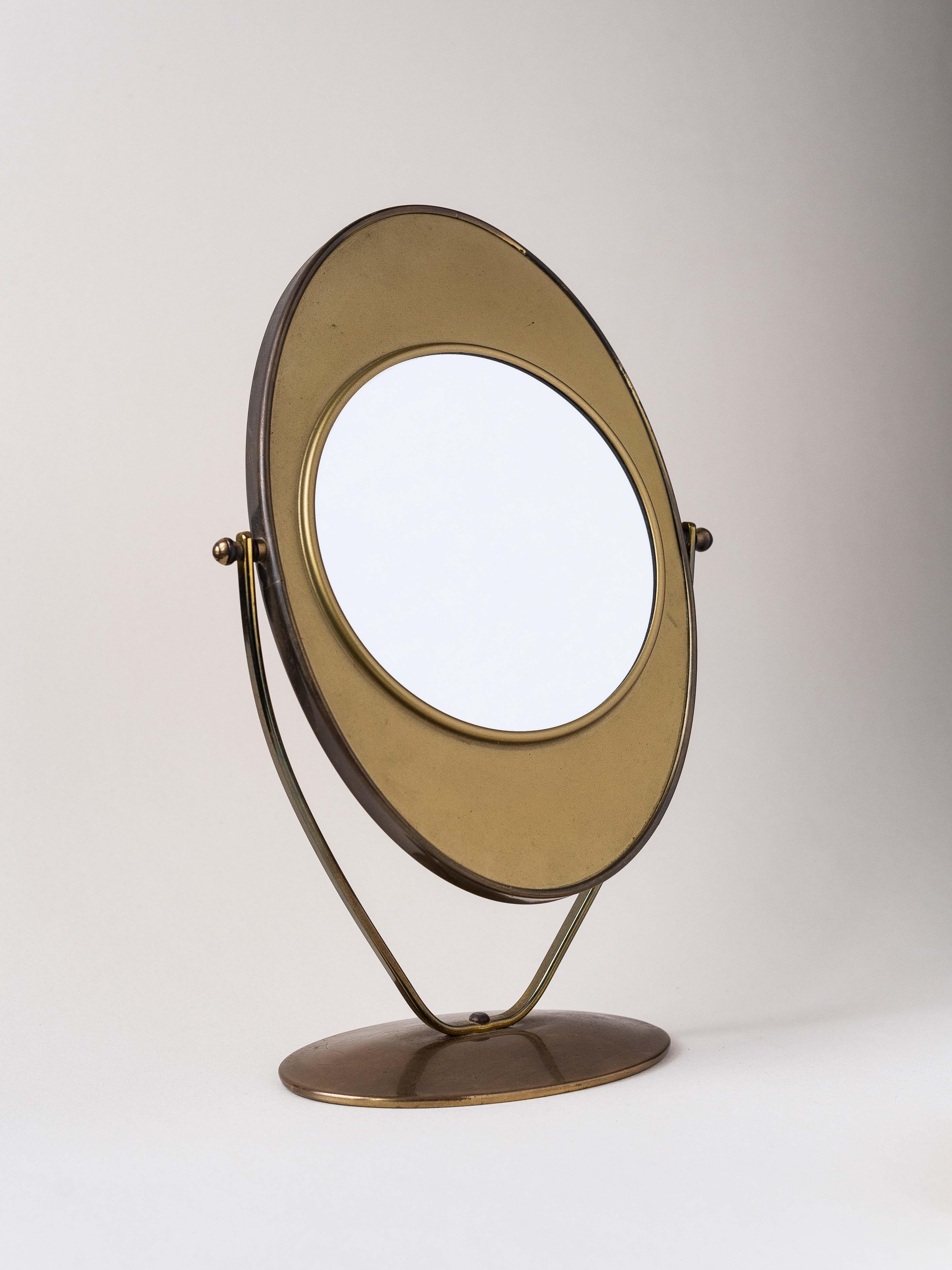 Elegant miroir de table double face, Circa 1960.

Entièrement en laiton patiné, forme générale dans le style de Charles Hollis Jones.

Le miroir peut être retourné pour être utilisé des deux côtés.

Un côté est un grand miroir classique, l'autre