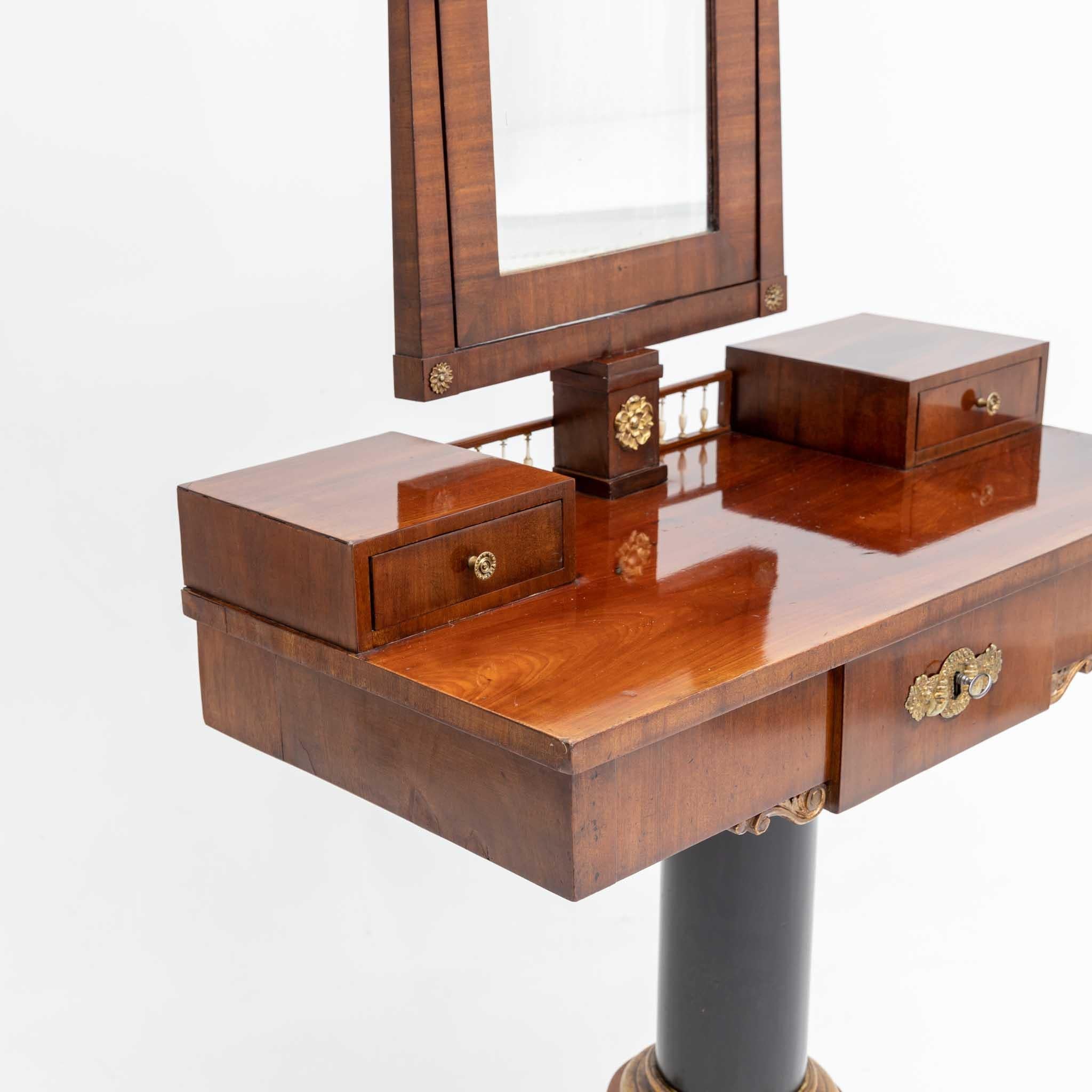 Danish Biedermeier dressing table with adjustable mirror with an architectural layout and fire-gilded fittings. The dressing table is equipped with two small drawers, a gallery rail and a wide drawer and stands on an ebonized column foot with a