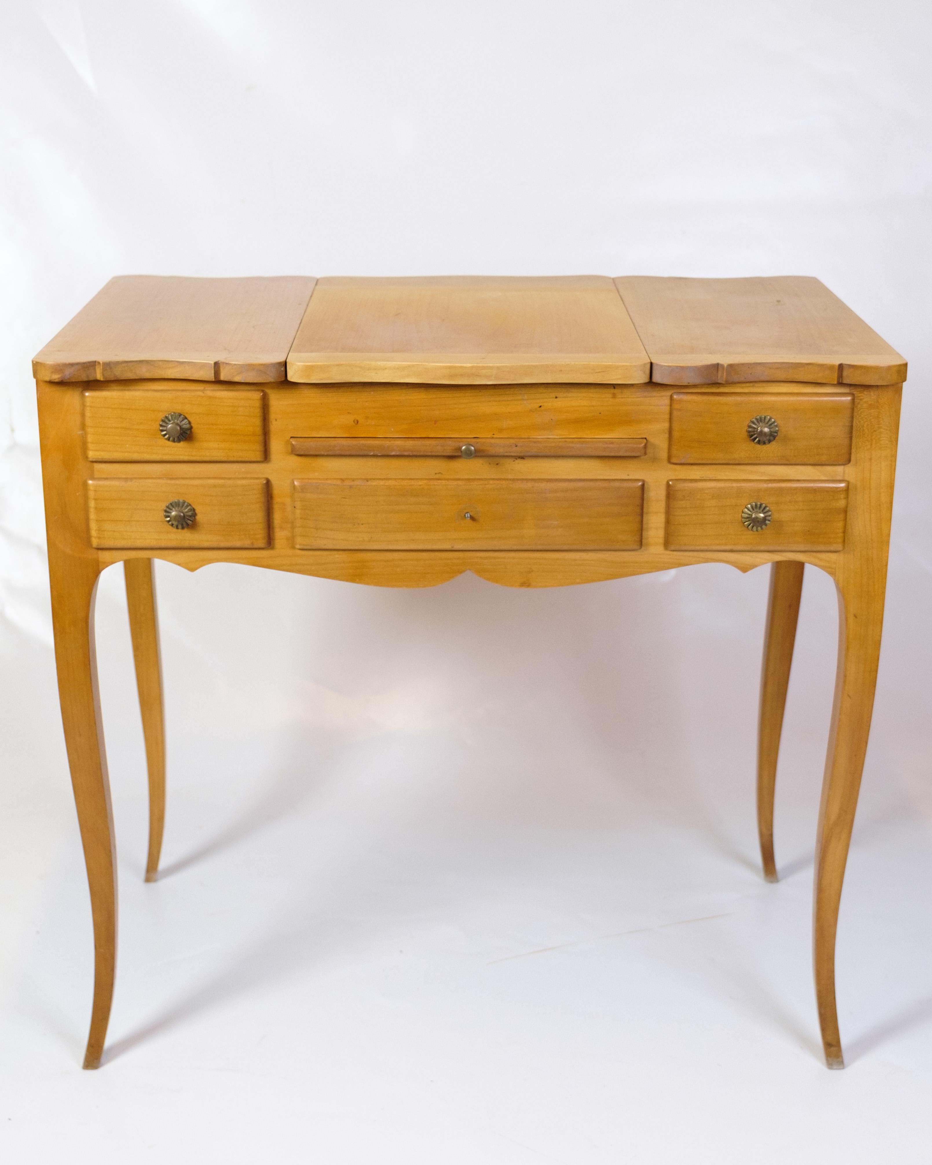 Coiffeuse avec tiroirs intégrés et miroir, en acajou clair, conçue dans le style Louis XV des années 1920. La table a des pieds courbés, des sculptures décoratives et des détails classiques qui caractérisent l'époque. Une coiffeuse élégante et