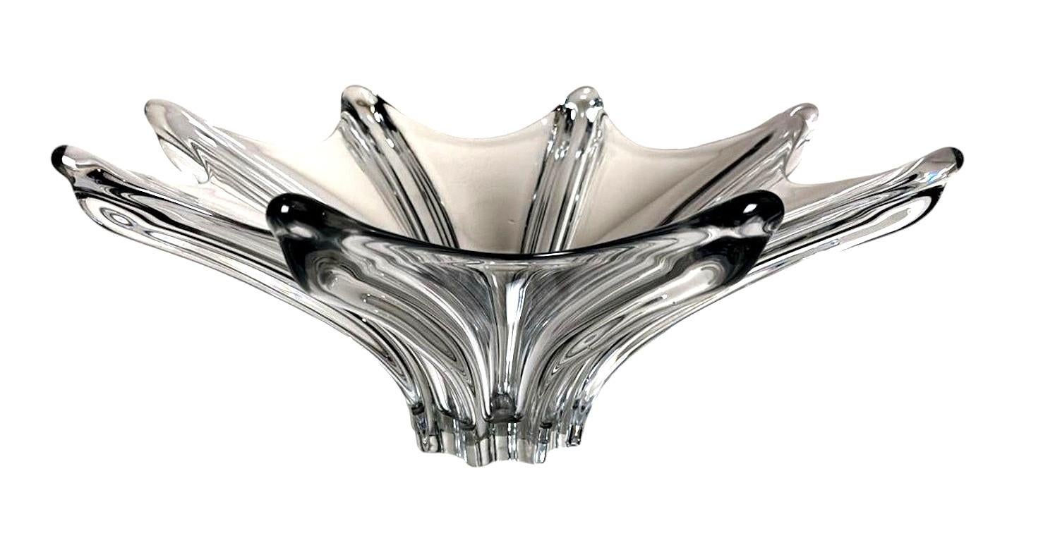 Eccezionale e importante centrotavola in cristallo al piombo in vetro trasparente. La sua silhouette, definita da curve morbide e bordi elegantemente arrotondati, affascina per il suo notevole senso di fluidità e leggerezza. I maestri vetrai hanno