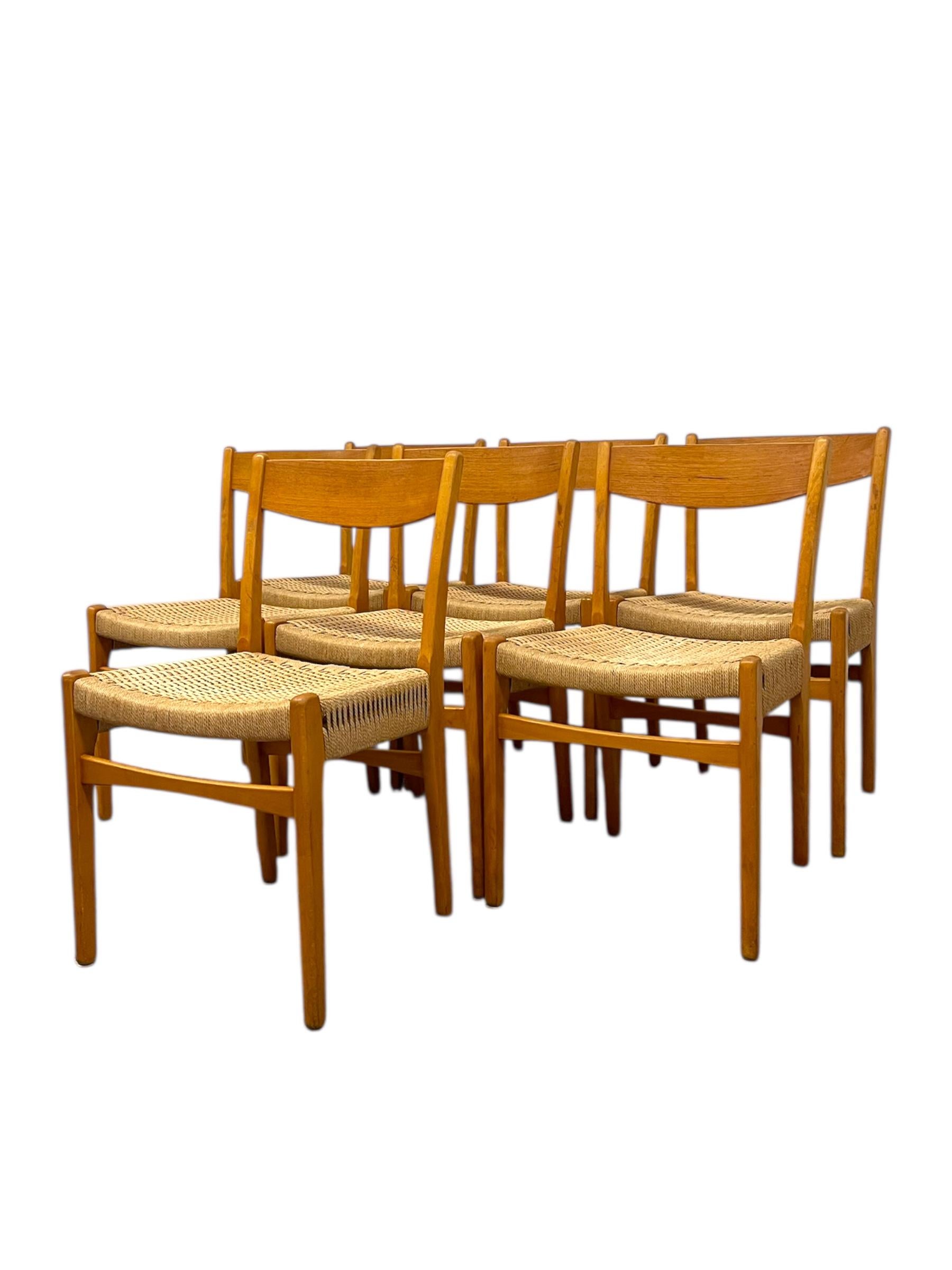 Ein klassischer Satz von sieben dänischen Esszimmerstühlen aus der Mitte des Jahrhunderts, der Skovmand & Andersen für Moreddi zugeschrieben wird. Jeder Stuhl zeigt die zeitlose Handwerkskunst und das minimalistische Design, das für dänische Möbel