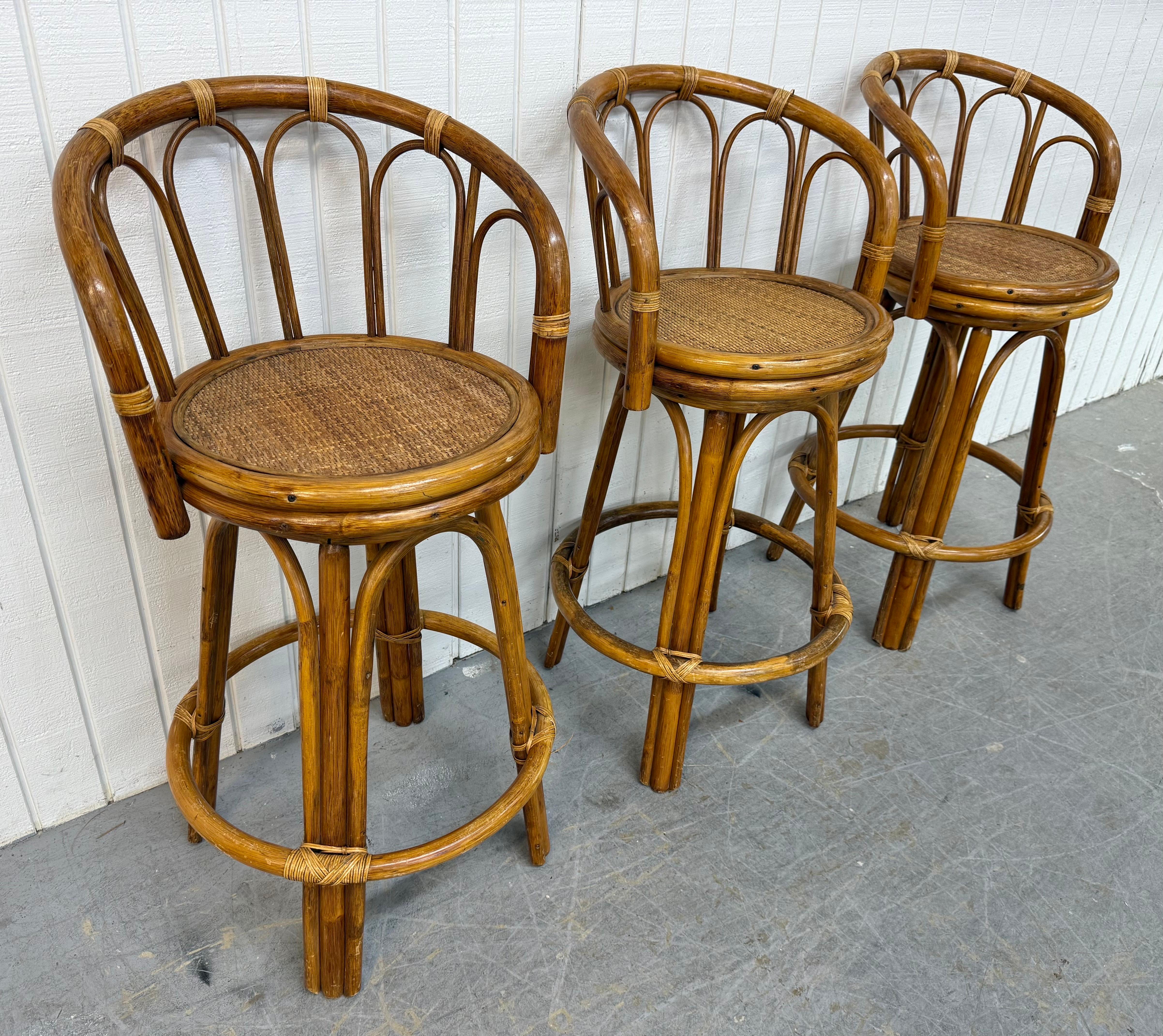 Cette offre concerne un ensemble de trois tabourets de bar pivotants en rotin vintage. Canne avec un design en rotin, une assise pivotante cannée et un dossier pour le soutien. Il s'agit d'une combinaison exceptionnelle de qualité et de design MCM !