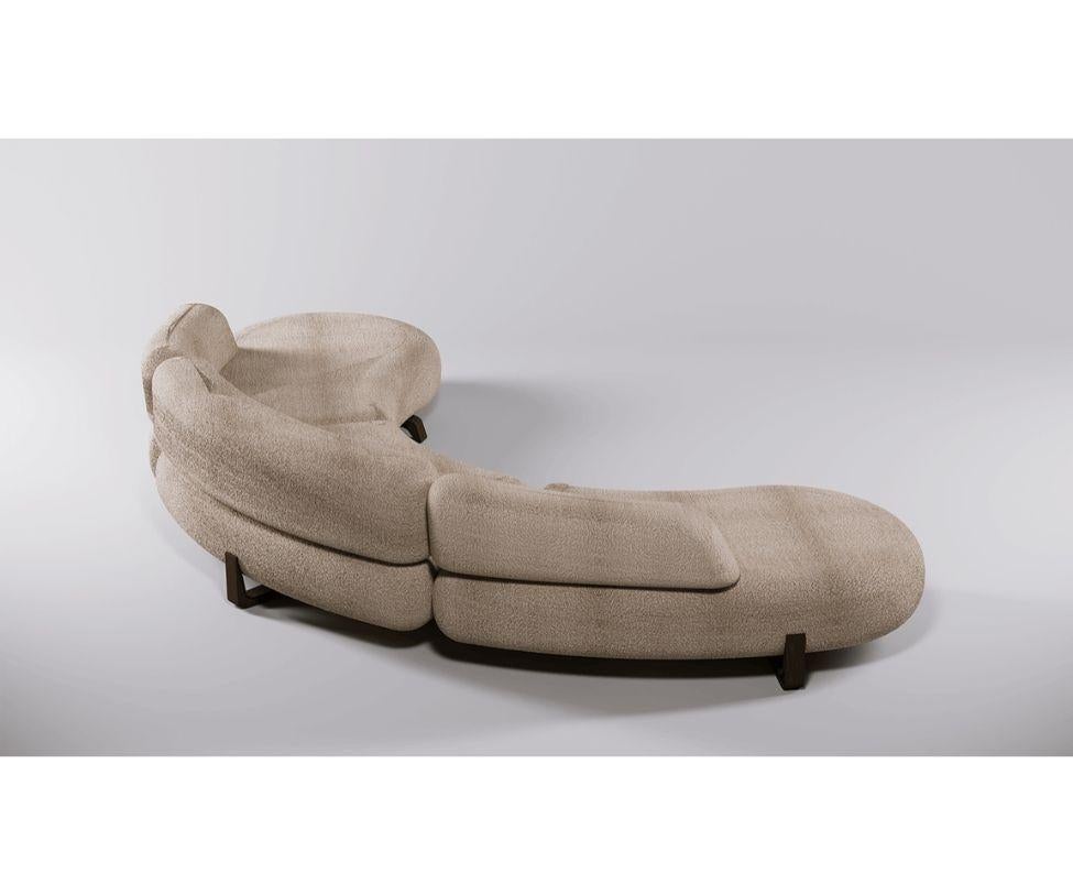 Sofá de tres plazas de forma sinuosa y amplias dimensiones, sostenido por una estructura de patas de fresno macizo ecológico desechado con acabado acético, cuyas imperfecciones le confieren un aspecto estético llamativo. 

Acolchado de caucho