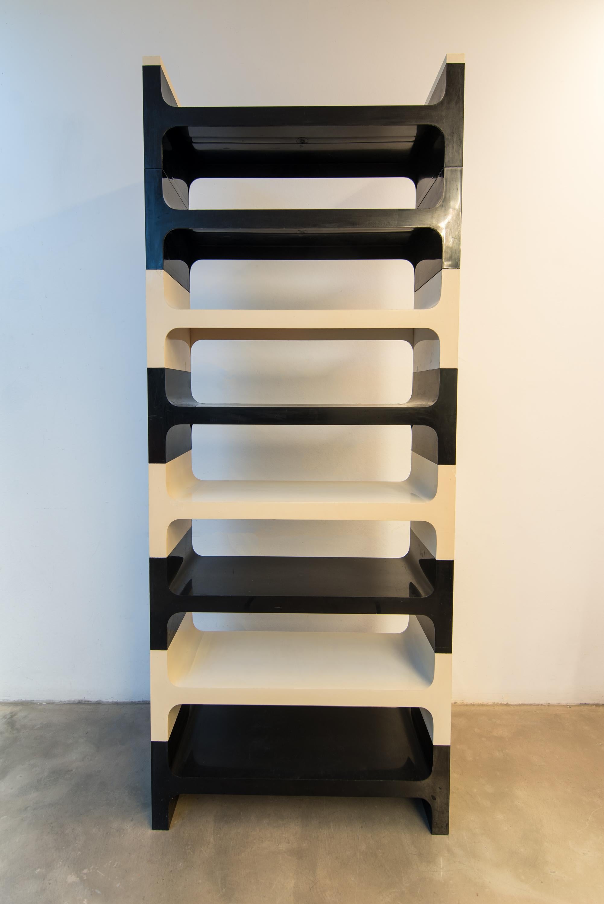 Vardani Design stacking shelf unit, Italy 1970s.
System consists in: 16 shelves, 3 round corners of three different colors (Black/White/Orange).

No breaks or repairs. Some tape residue. Some light surface scratches. Comprised of twenty-three