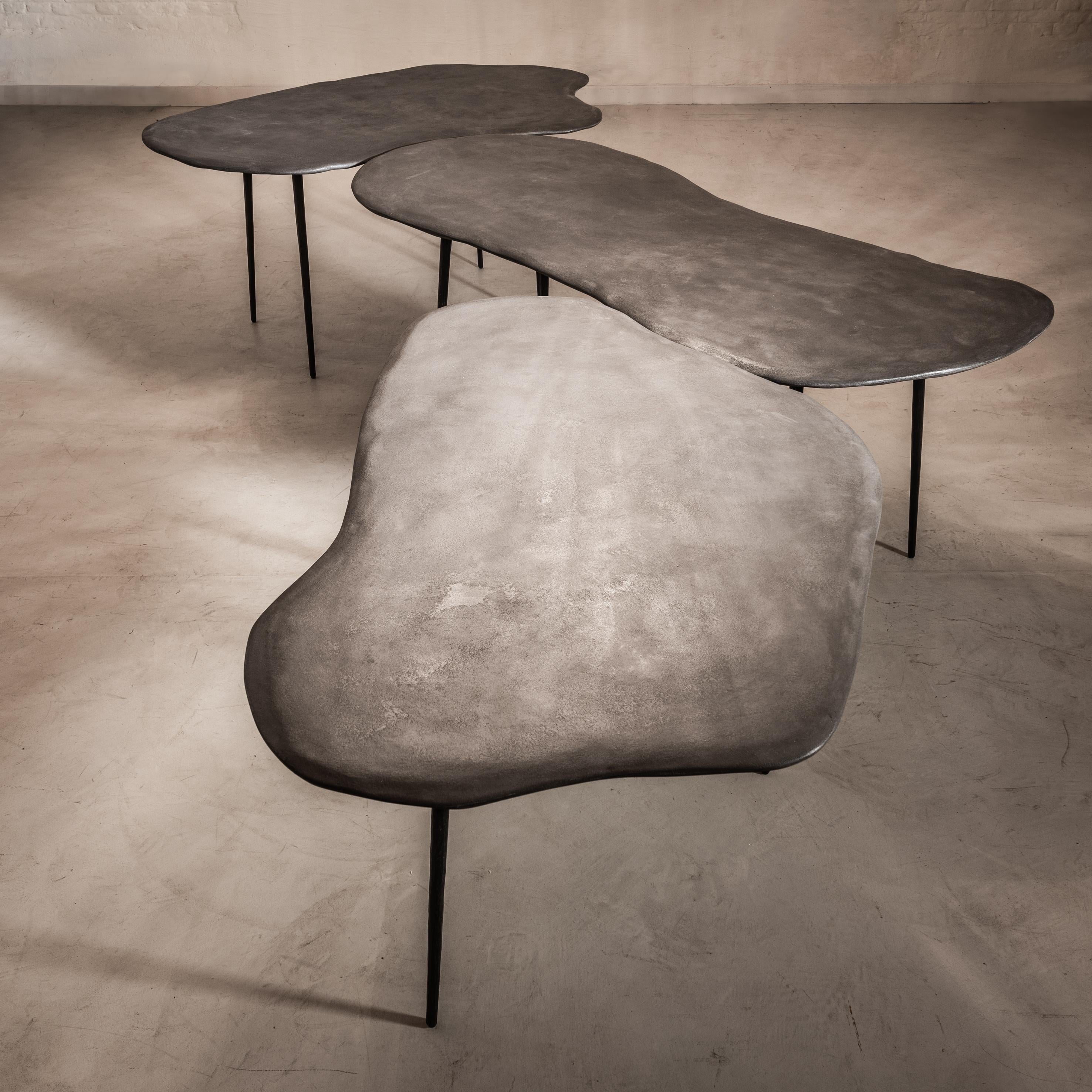 Varenna table Trio by Studio Emblématique
Dimensions: 
- W 157 x D 92 x H 76 cm
- W 162 x D 95 x H 76 cm
- W 200 x D 85 x H 76 cm
Materials: Stonegrain table top with conical metal hammered legs

Pushing the boundaries, going the extra mile