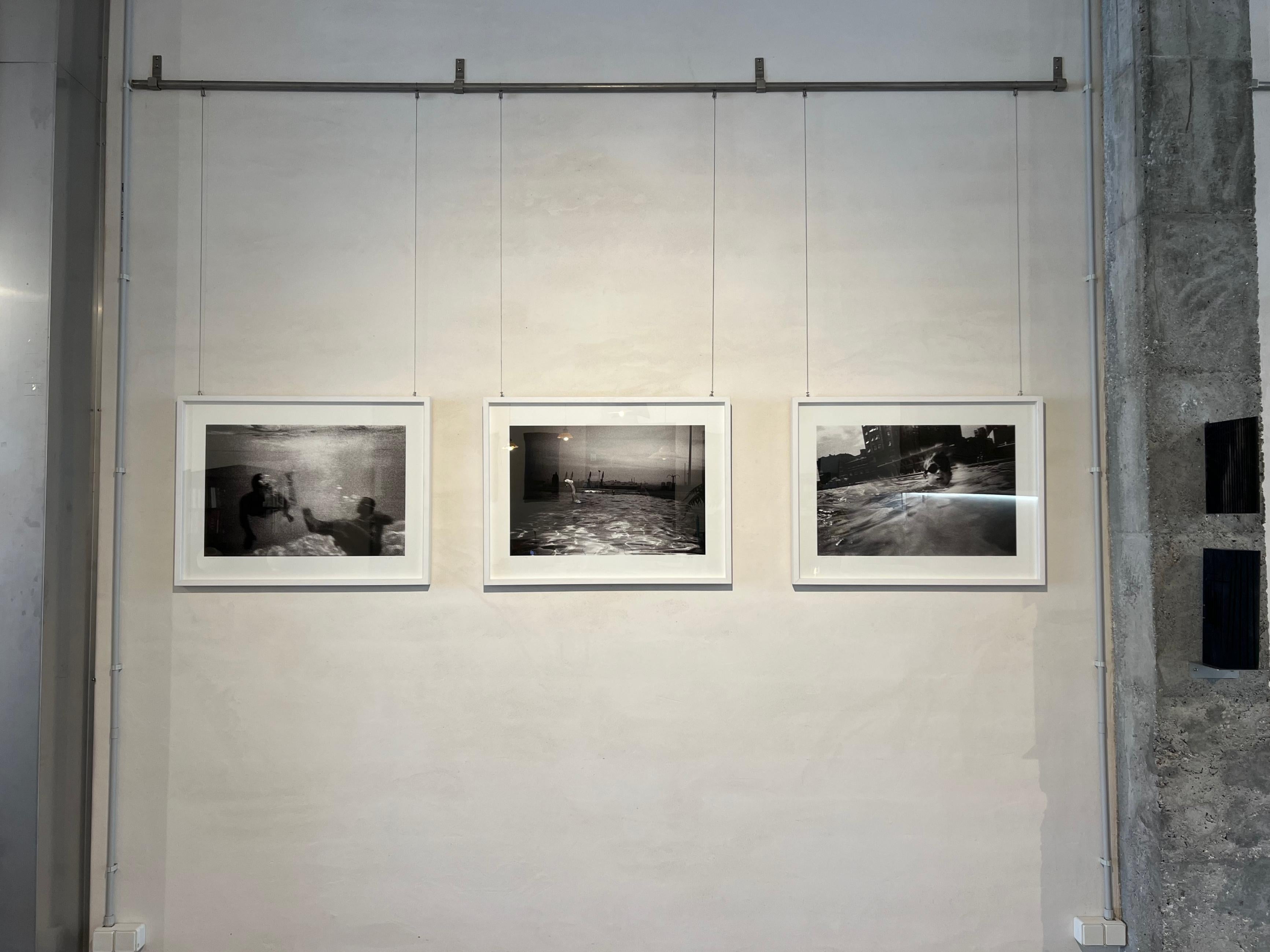 Analog photography of swimmers, lights in the water, moving image, black & white - Photograph by Vari Caramés