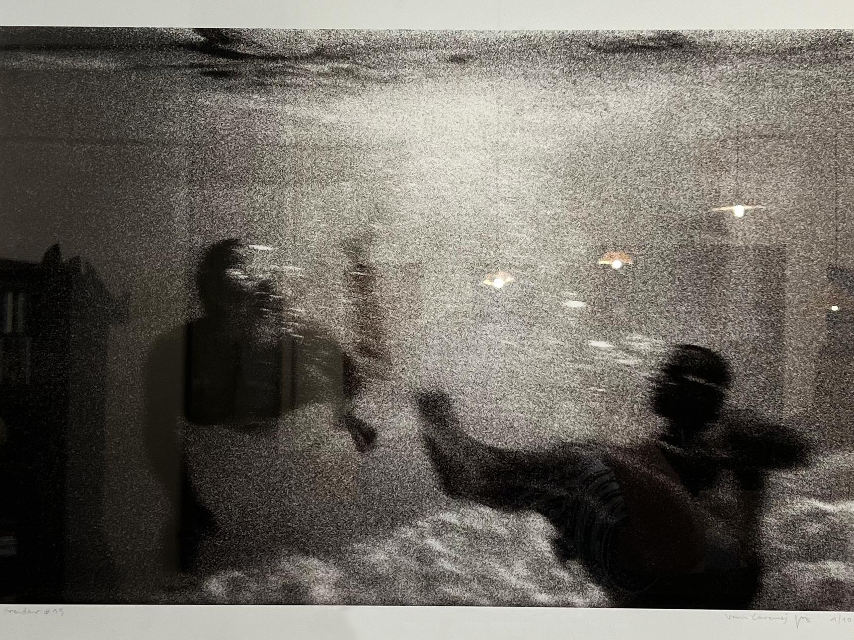 Analog photography of swimmers, lights in the water, moving image, black & white - Gray Portrait Photograph by Vari Caramés