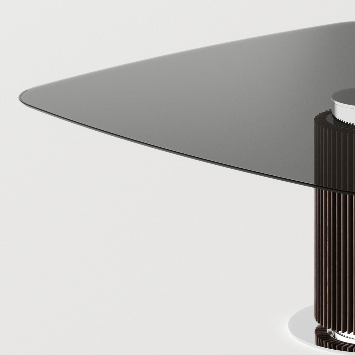Dining Table Variation Square with central base in solid wood
in eucalyptus stained finish, with polished stainless steel ground 
base and with up central base in polished stainless steel finish.
With smocked glass top with rounded corners.