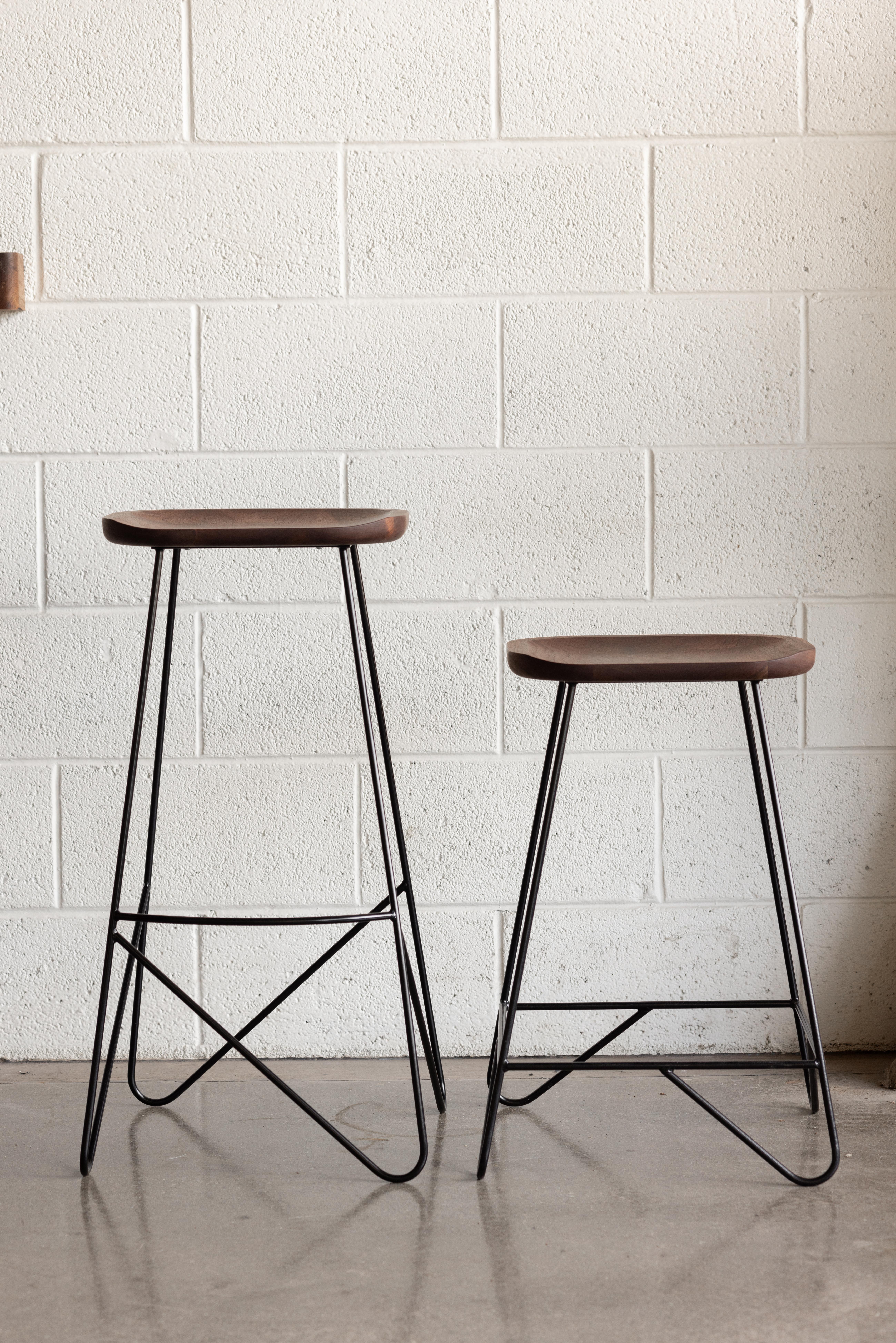 Variante de la série des tabourets à tige d'acier, le Varilla est un tabouret à hauteur de bar doté d'une assise en bois dur scoop. Grâce à sa simplicité, il ajoute une touche de design moderne à n'importe quel espace. Nous avons mis l'accent sur le