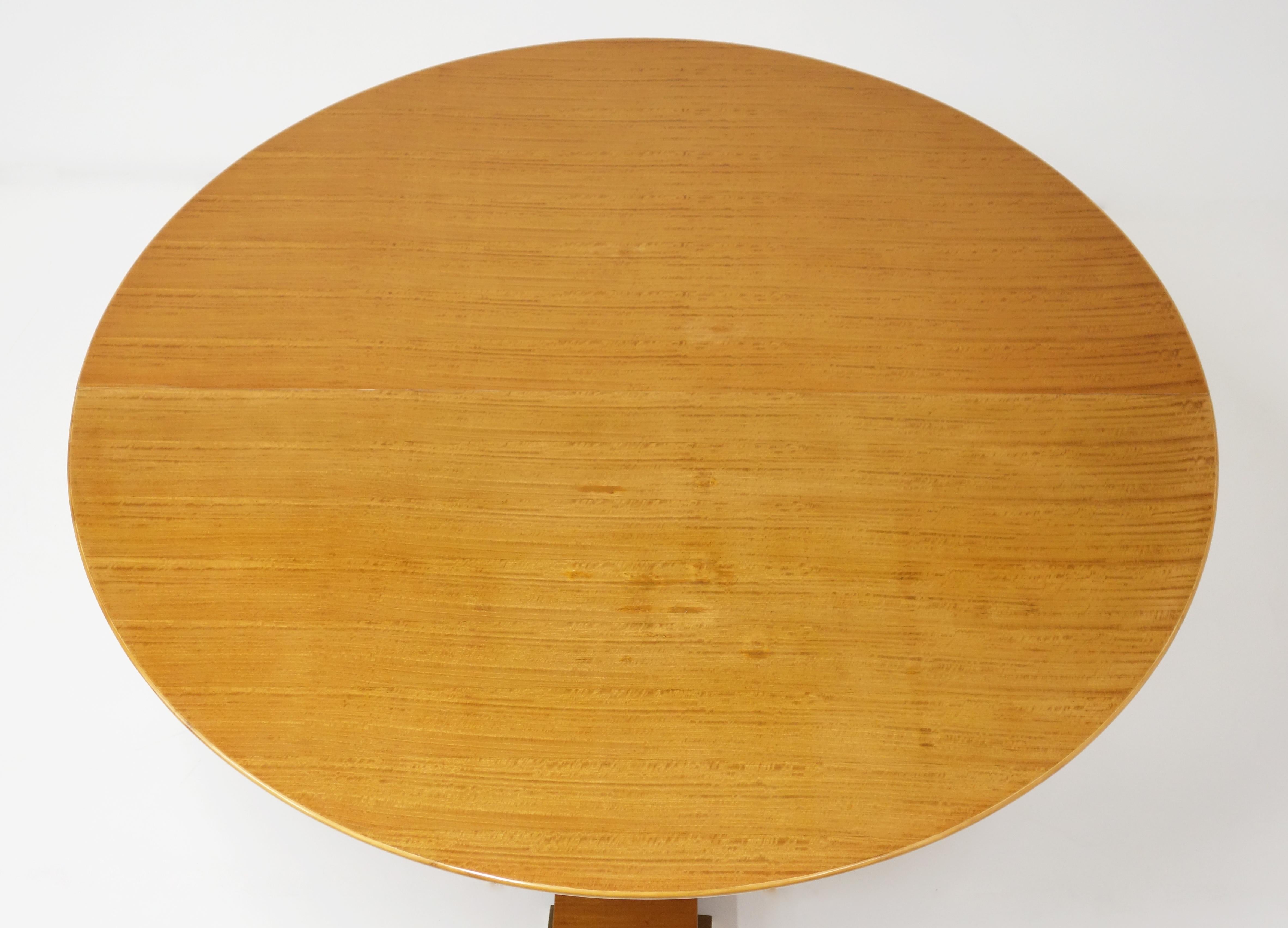 Varnished Lemon-tree circular table by Jean Royère, circa 1950.
The wing-shaped circular top stands on a central foot composed of three spindle-shaped columns. Each column is set with a circular gilt bronze ring.
The table stands on a base set off