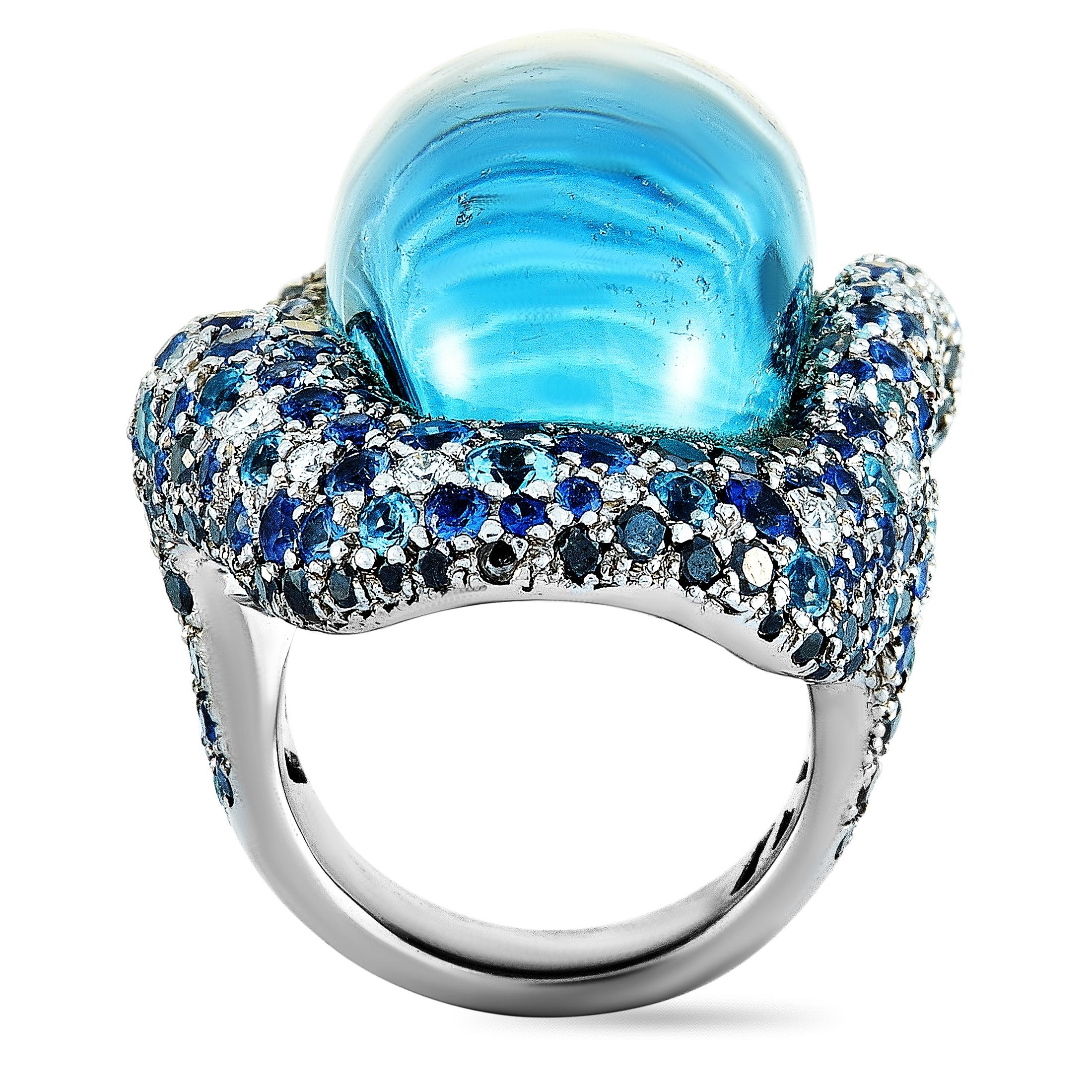 This Vasari ring is made of 18K white gold and weighs 41.5 grams. It boasts band thickness of 5 mm and top height of 14 mm, while top dimensions measure 26 by 40 mm. The ring is set with a topaz, a total of 3.00 carats of sapphires, and with black