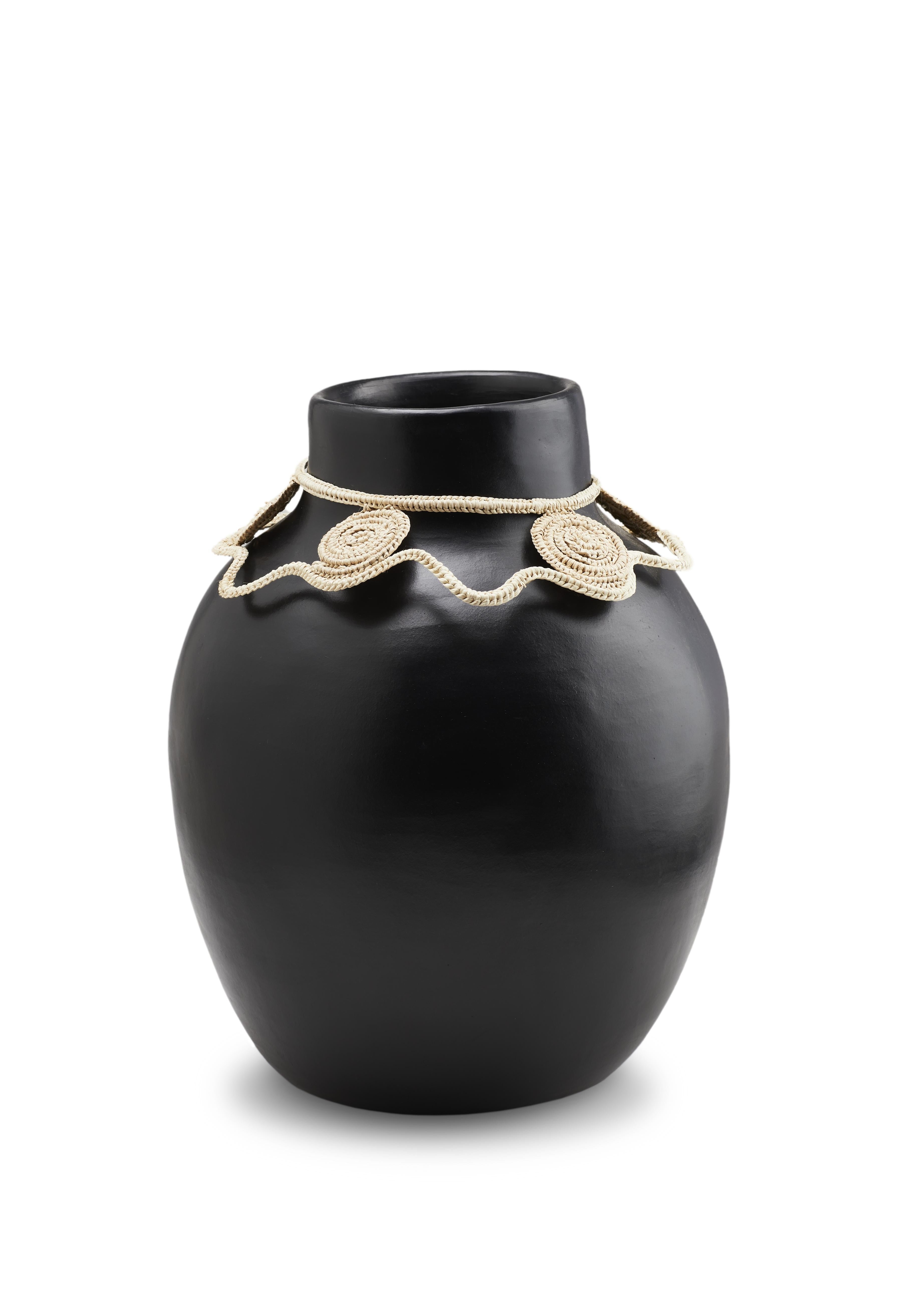 Vase, 2 Karat, von Cristina Celestino 
MATERIALIEN: Hitzebeständige schwarze Keramik. Fasern aus Jipi-Palmblättern Fasern
Technik: Glasiert. Im Ofen gegart und mit Halbedelsteinen poliert. Handgewebt. 
Abmessungen: Durchmesser 20 cm x H 30 cm
