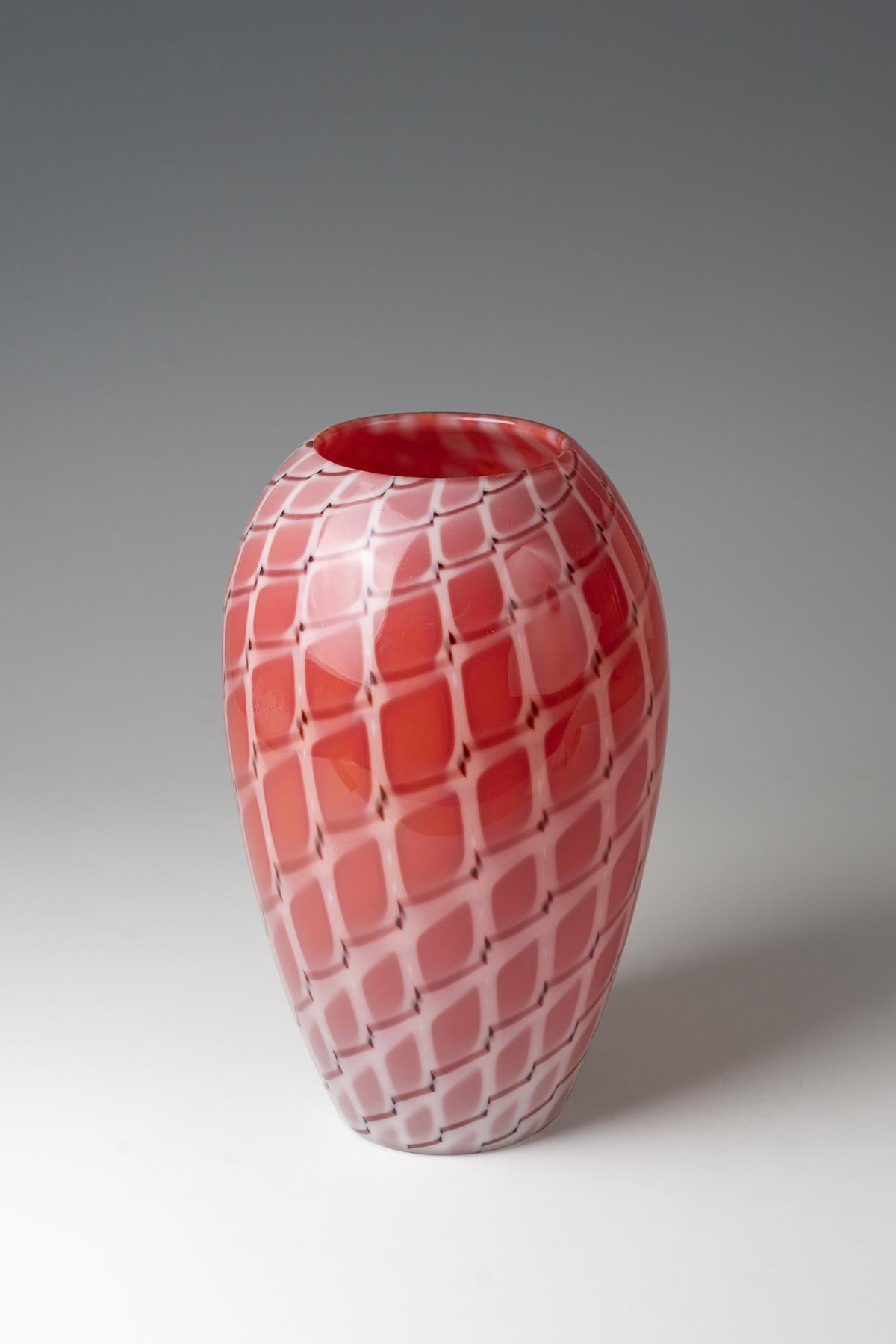 Vaso ''A losanghe'' Archimede Seguso, Murano, 1952 circa Vetro incolore con piastrine a forma di diamante densamente fuse in rosso-arancio opalescente, contornate da bacchette di vetro ''a canne'' in bianco opalino e viola. H. 28 cm

Condizioni