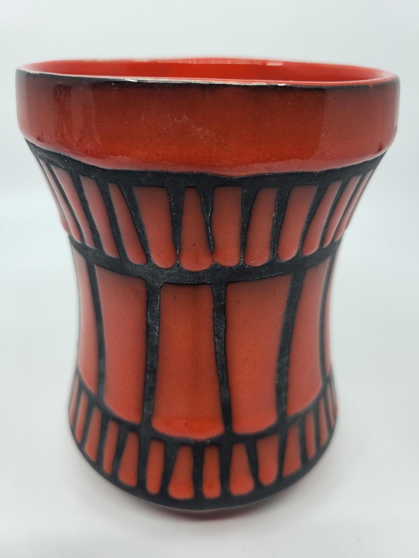 Le vase ou chope ansée de Roger Capron, réalisée en céramique rouge, est une pièce emblématique du design des années 1950. Provenant de Vallauris, sur la Côte d'Azur, cette œuvre reflète parfaitement le style méditerranéen et l'esprit artistique de