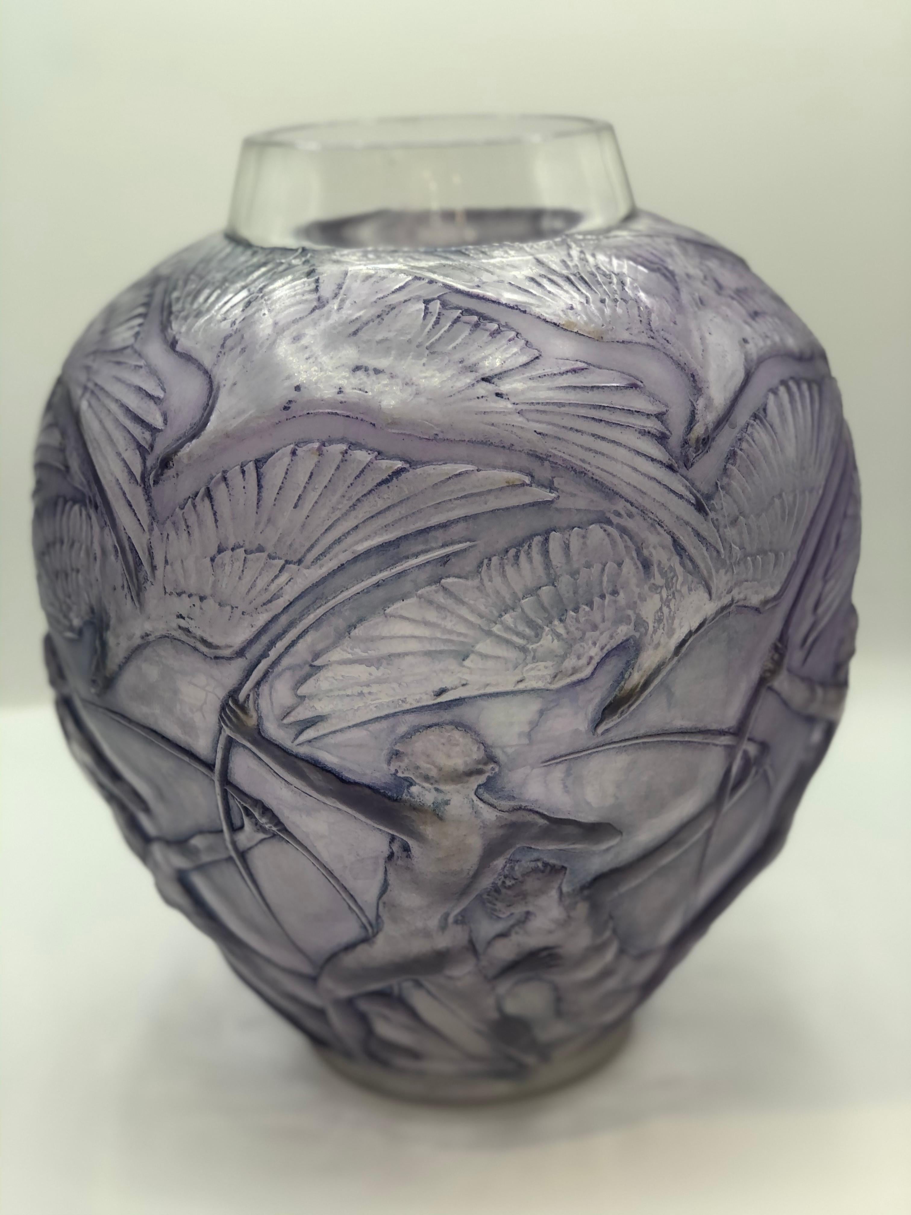 Rene. Lalique: Vase having an all-over design of nude bowmen aiming arrows at large swooping overhead birds. 28cm tall clear, frosted, and patinated purple glass.
model cretated et producted from 1921 to 1947.