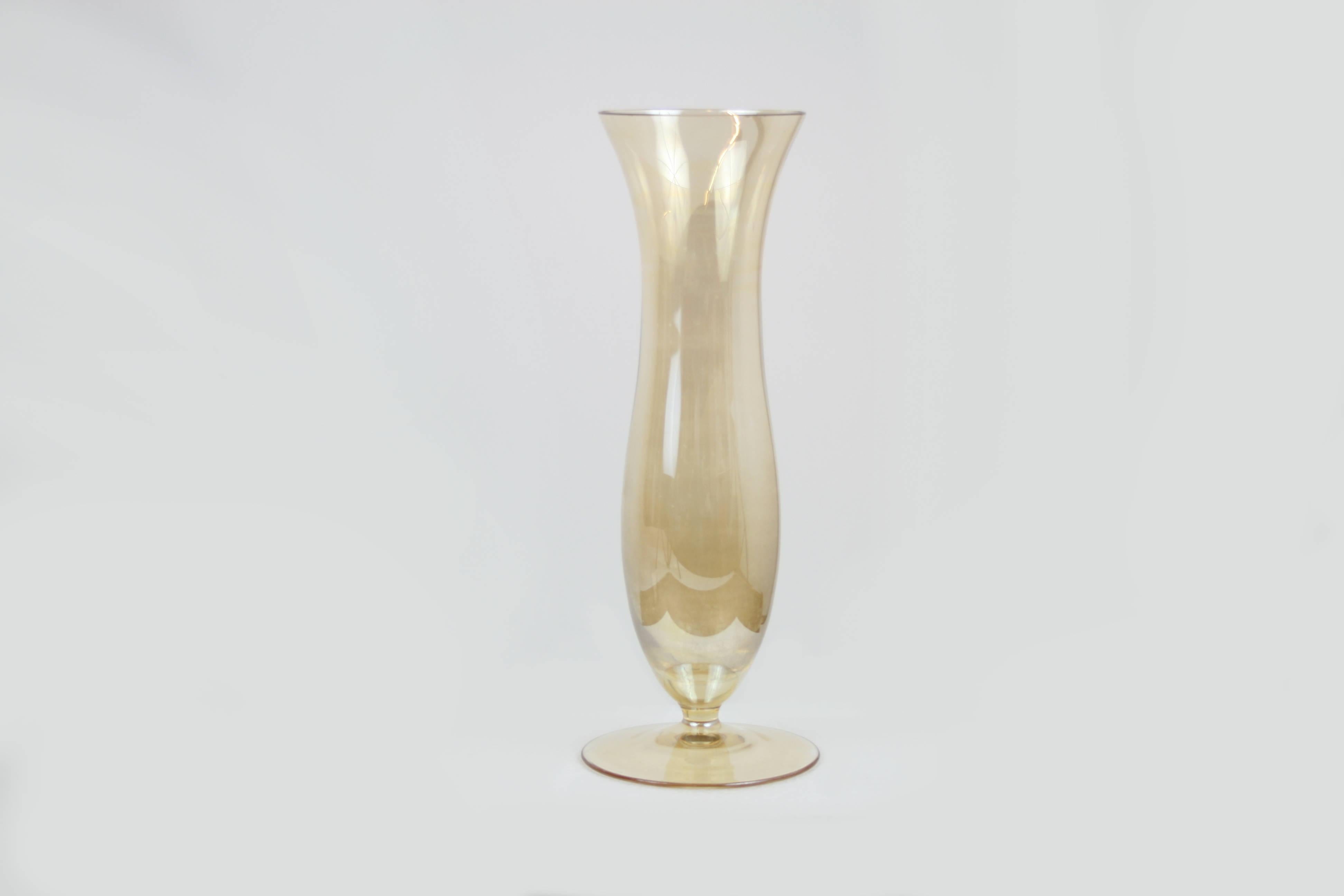 A hue of shimmering amber that is not easily captured in photography is our first impression by looking at this treasure of nearly two centuries of Austrian glass manufacturing tradition. Slenderly curved and of sublime elegance this object is