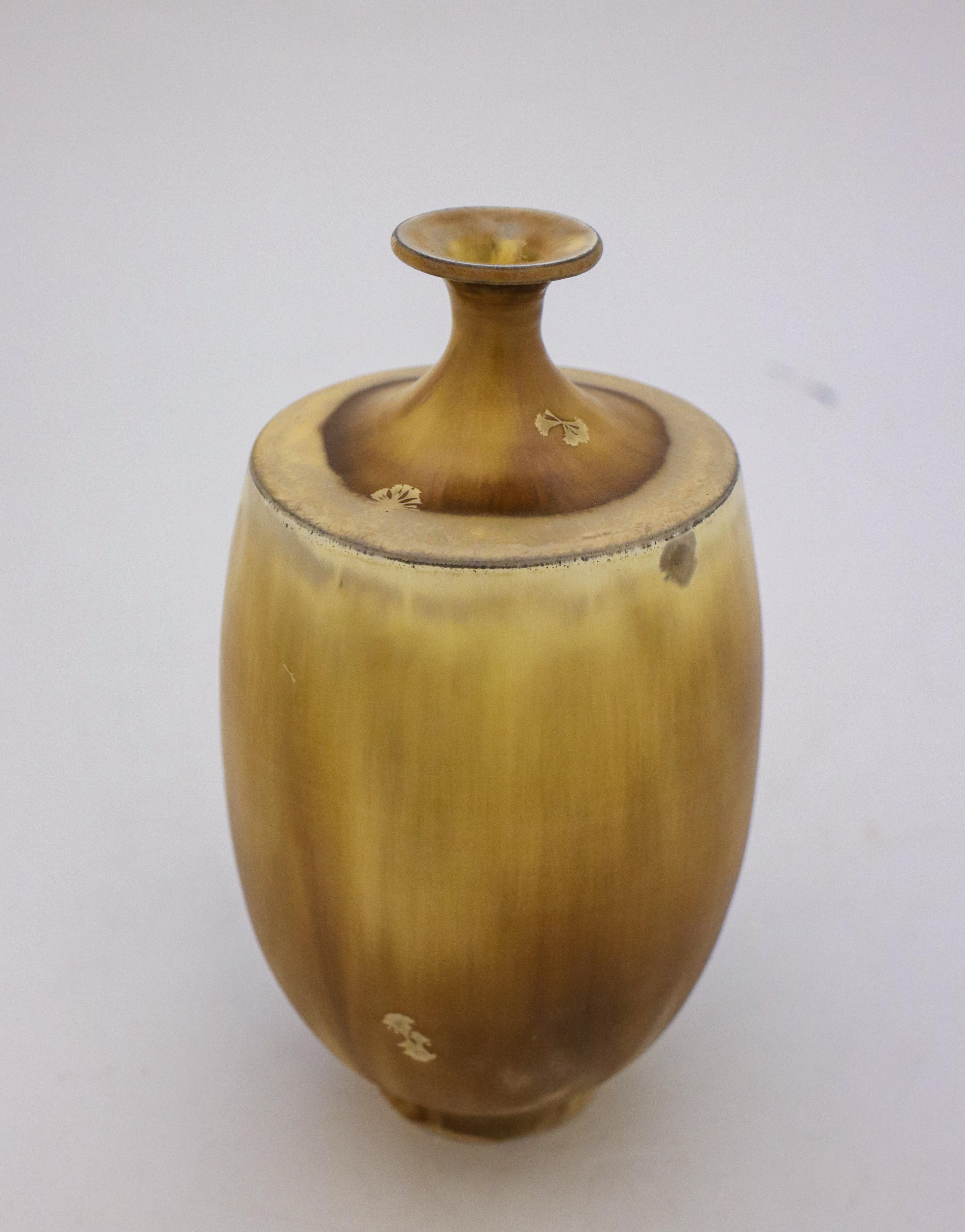 A unique vase in a beige / brown color with a crystalline glaze created by the contemporary Swedish artist Isak Isaksson in his own studio. The vase is 21 cm (8.4