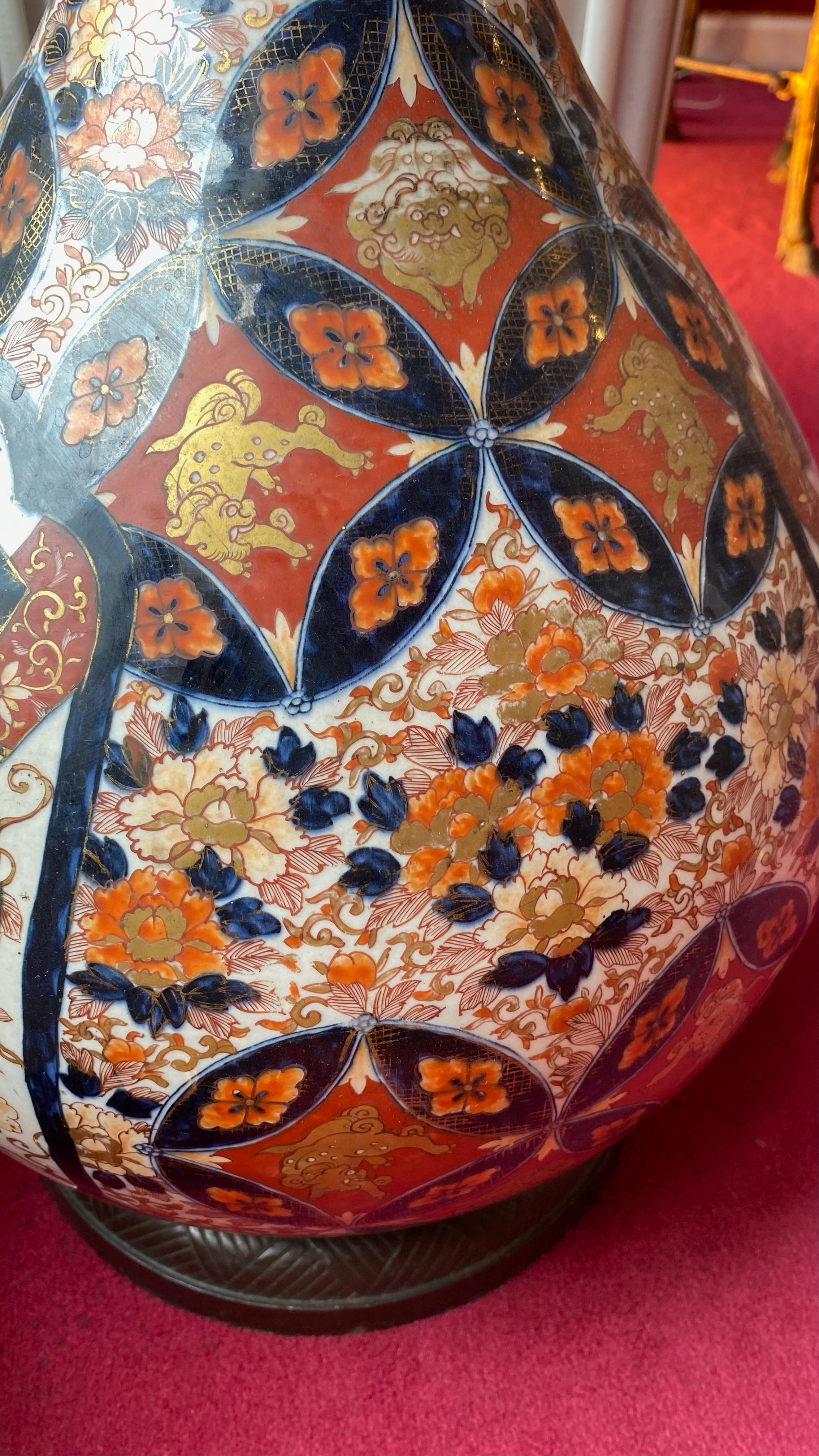 VASE BOUTEILLE, EPOQUE EDO (1603-1868), XVIIIè SIÈCLE.
TRAVAIL JAPONAIS, IMARI. 
Grand vase bouteille en porcelaine à décor en bleu sous couverte, rouge de fer et émail or de belles de jour, brocarts en médaillon, shishi en médaillons et pivoines