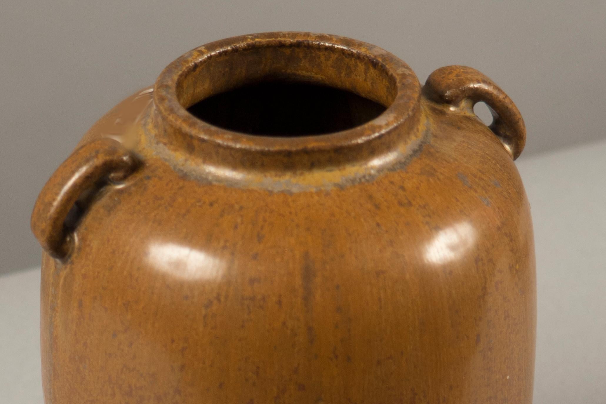 Stoneware vessel with two small handles, decorated in a brown glaze.
   