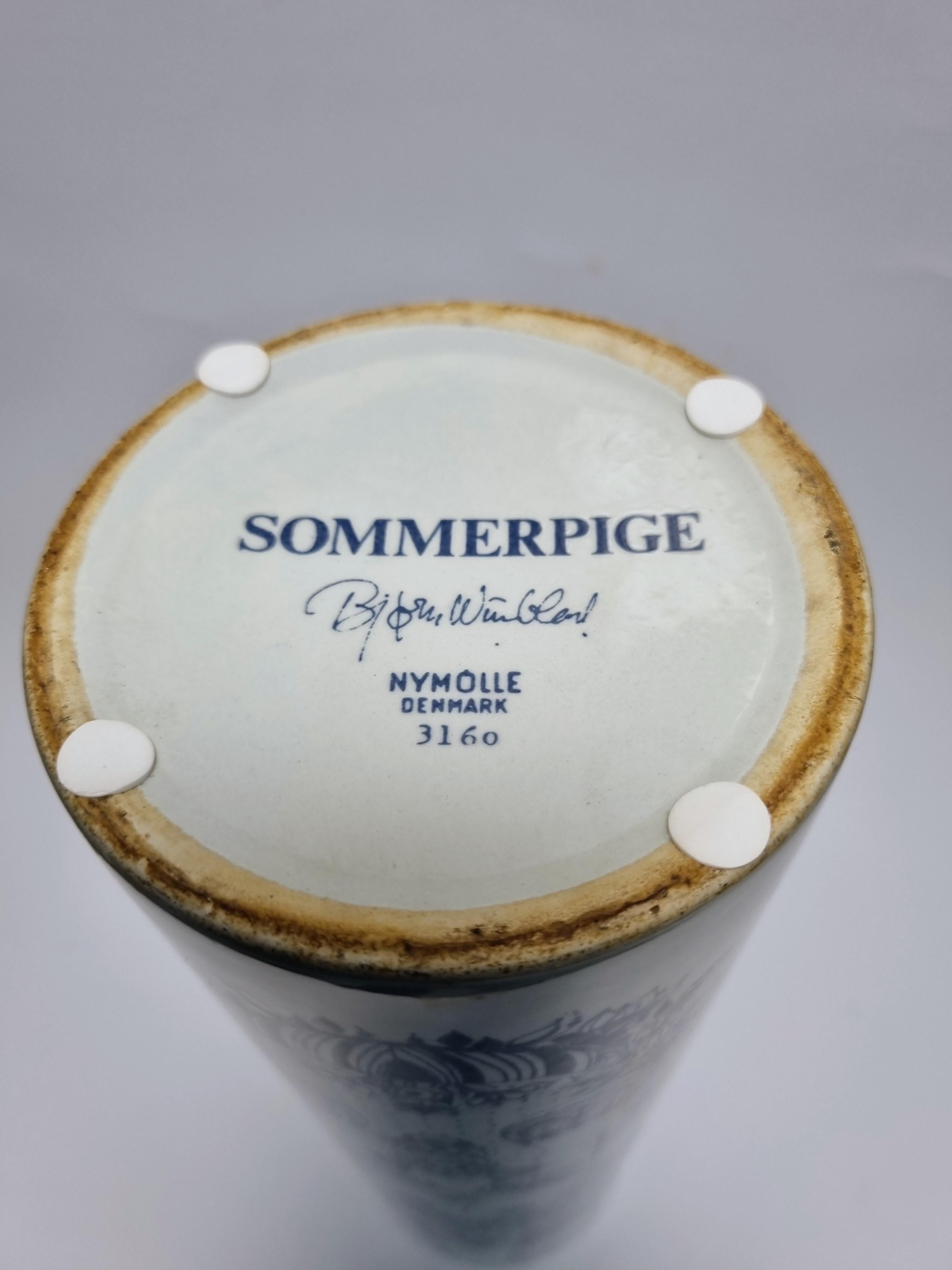 White vase decorated in blue. 
Model 3160 Sommerpige designed by Bjørn Wiinblad and manufactured at Nymølle.