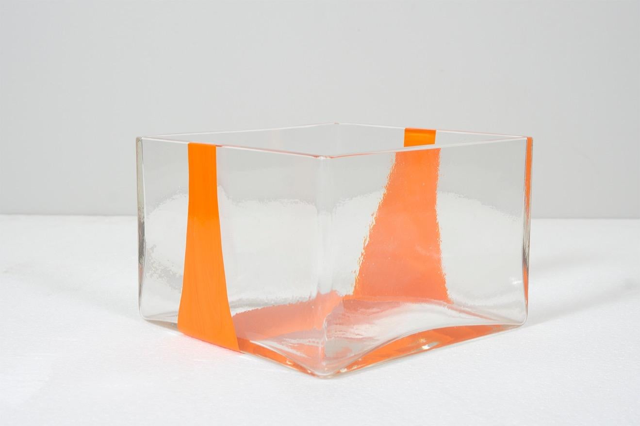 Vase made of crystal glass with an orange band 
Design / Ludovico Diaz de Santillana (for Pierre Cardin)
Dimensions: H 12.3 cm, 18 x 18 cm
Manufacturer / Venini, 1969.

     