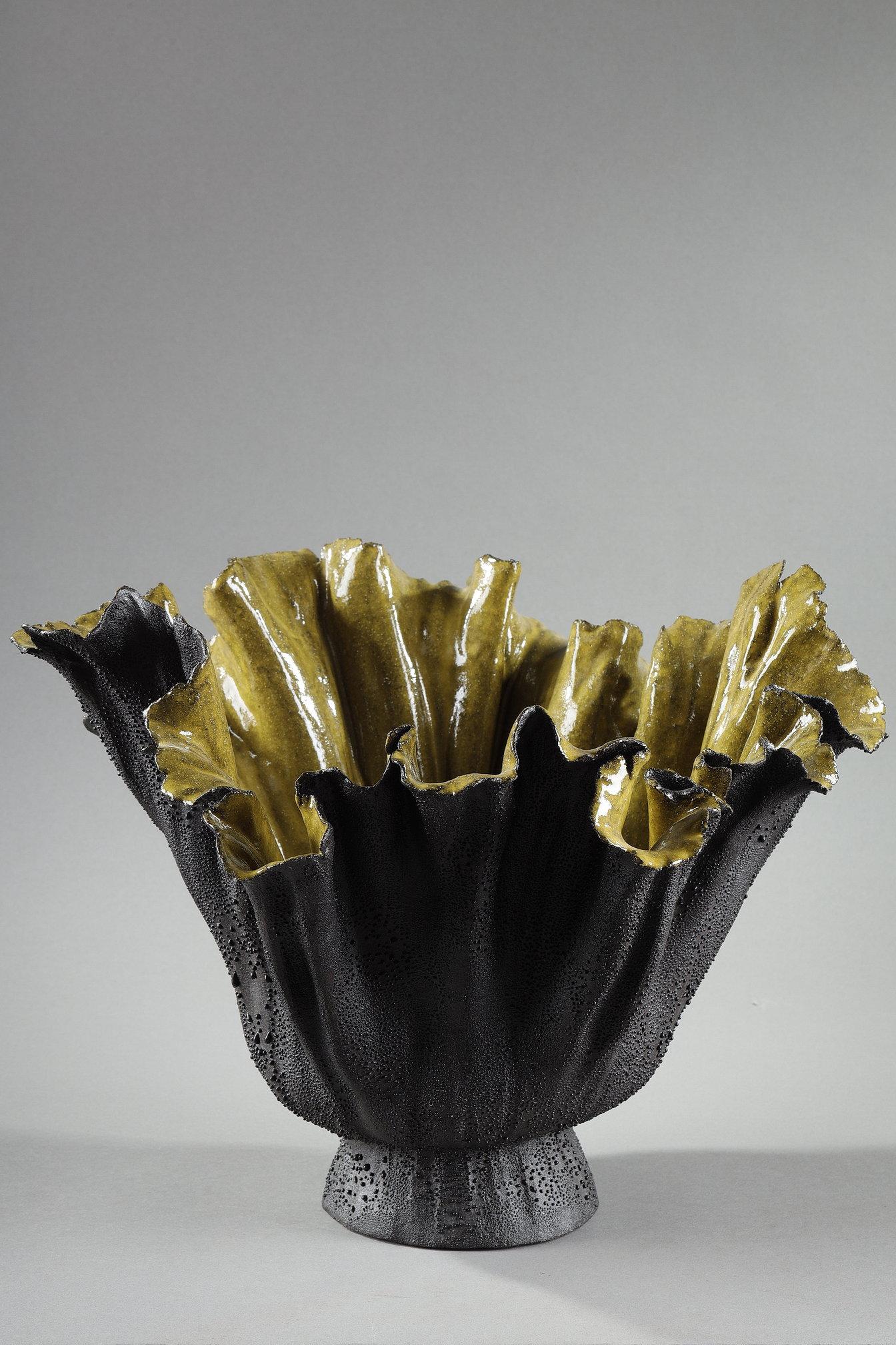 Superb contemporary vase by Lebanese artist Nayla Sirgi. This masterful piece is distinguished by its organic silhouette, both powerful and delicate. The body of the vase, in textured black stoneware, embraces undulating forms evocative of mineral