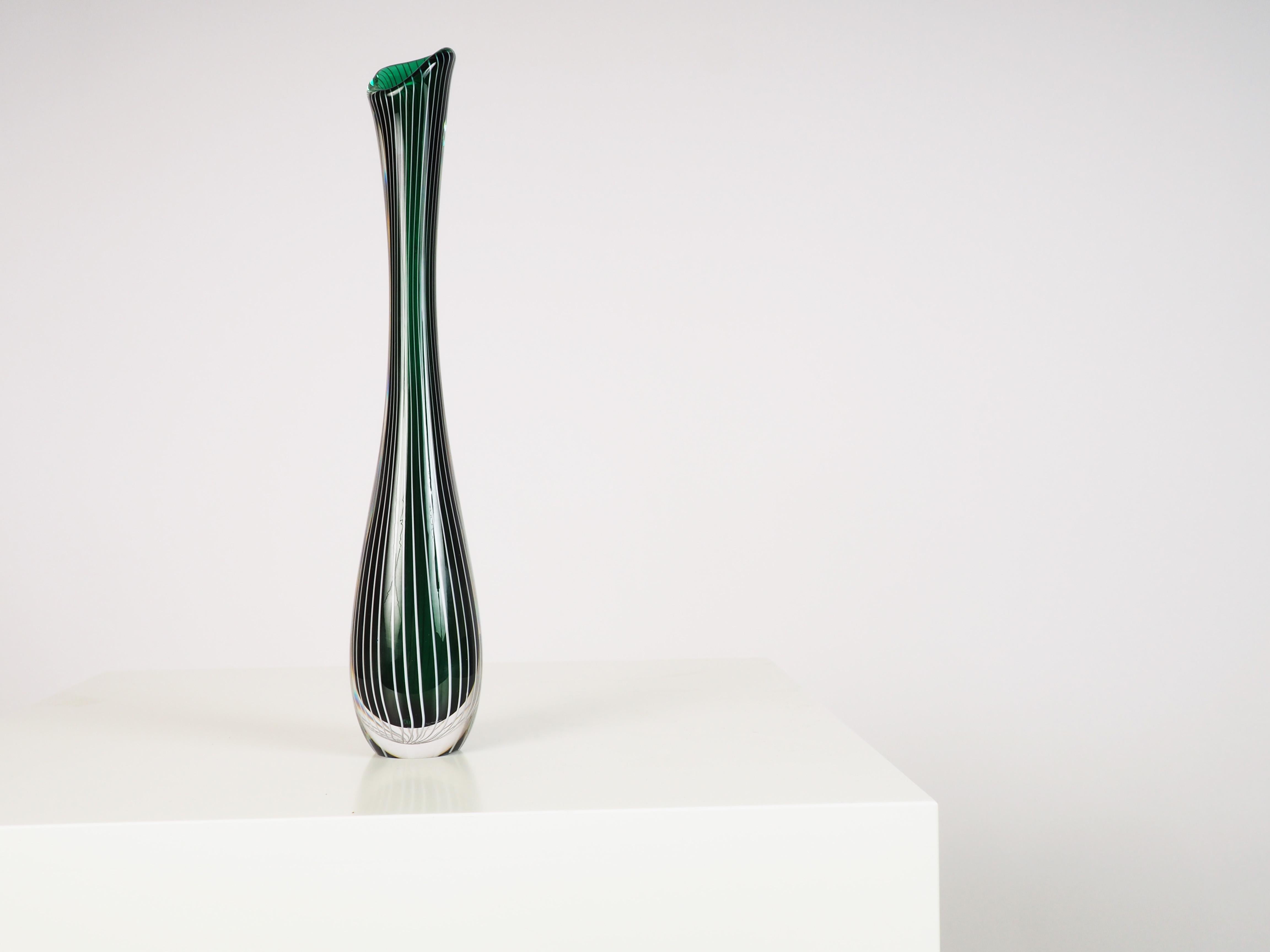 Tall glass vase by the Swedish glass artist Vicke Lindstrand for Kosta Glasbruk. The vase was designed in the 1950s when Vicke Lindstrand returned to his favorite material: handcrafted glass.
The vase is in party green, partly clear glass, with a