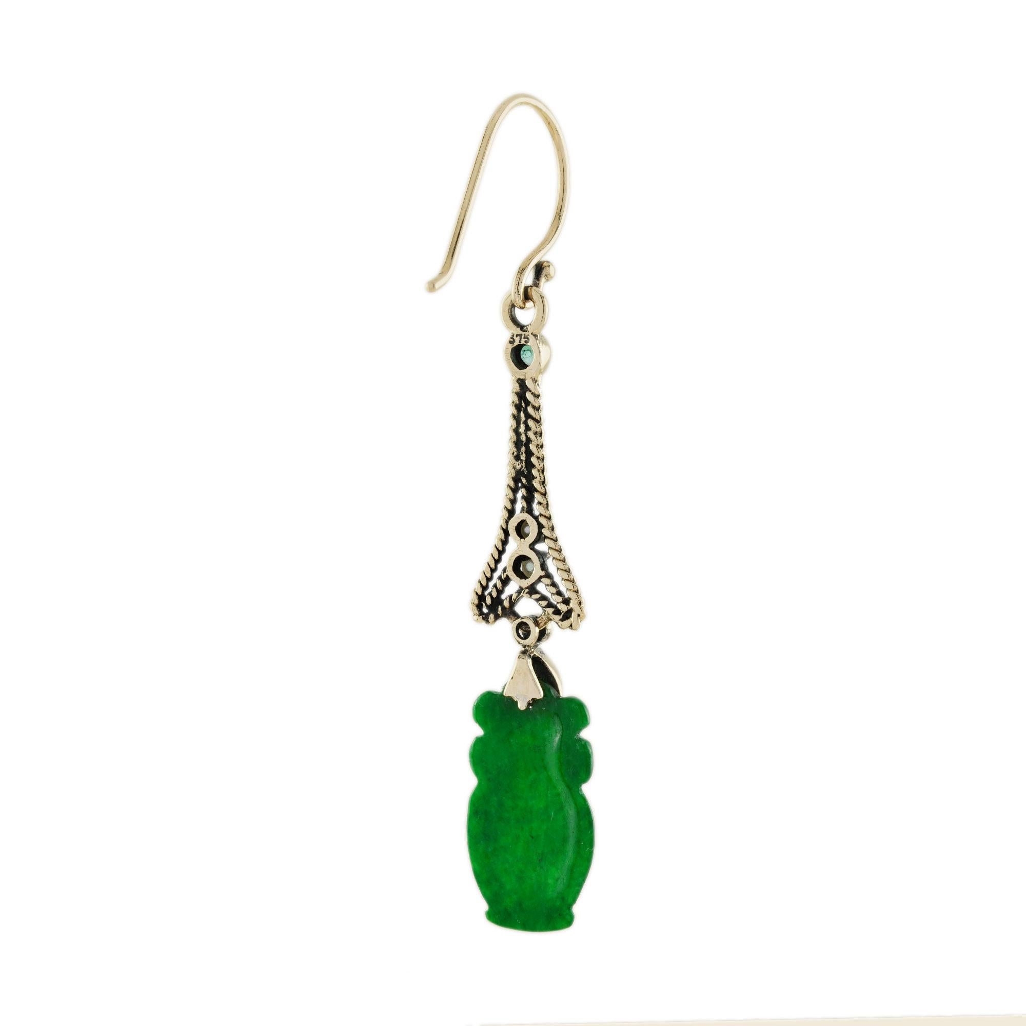 The natural jade in these lovely earrings has some very special shape. Both pieces have a strong green color and well vase carvings. The jade is suspended in a 9k yellow gold setting with pearl, diamond, and emerald geometric link on the top. The