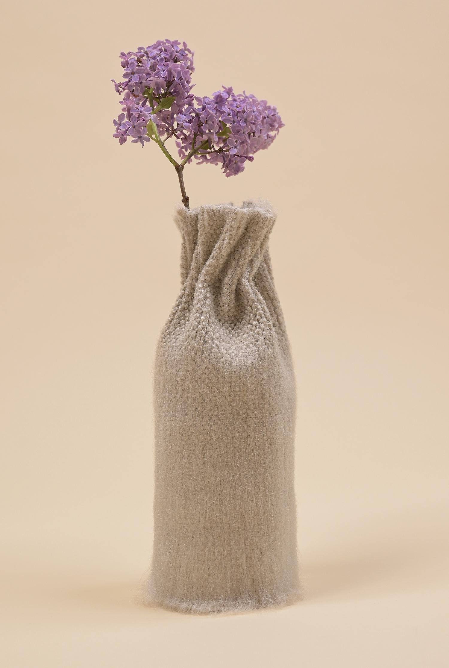 This product belongs to our Collection N°2 - a collection that explores the delicate process of blending in from a social point of view.

This vase (highball glass cover) is knitted as a flat textile with engineered holes. When threaded and pulled