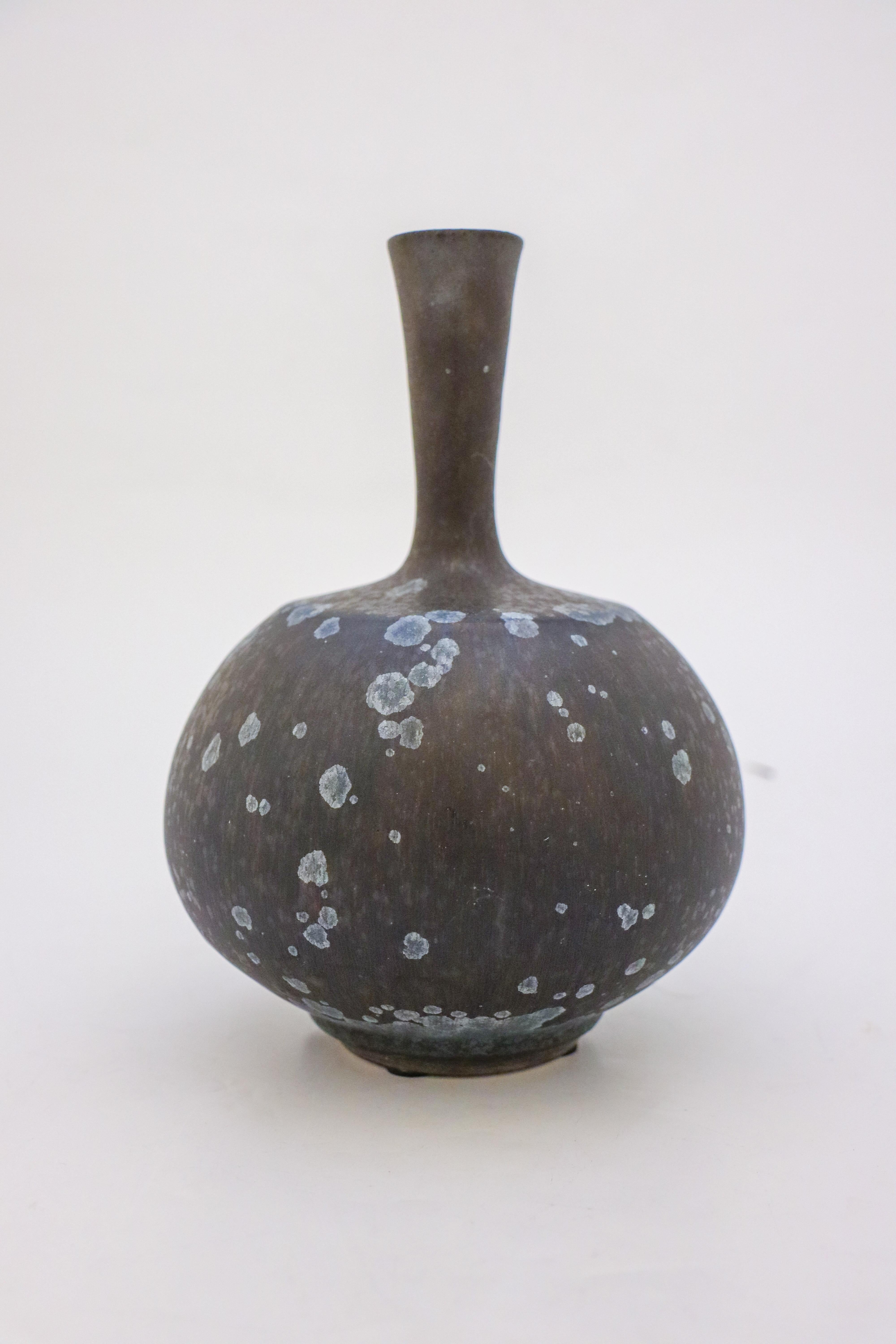 A unique vase in a black and dark blue color with a lovely crystalline glaze created by the contemporary Swedish artist Isak Isaksson in his own studio. The vase is 20.5 cm (8.2