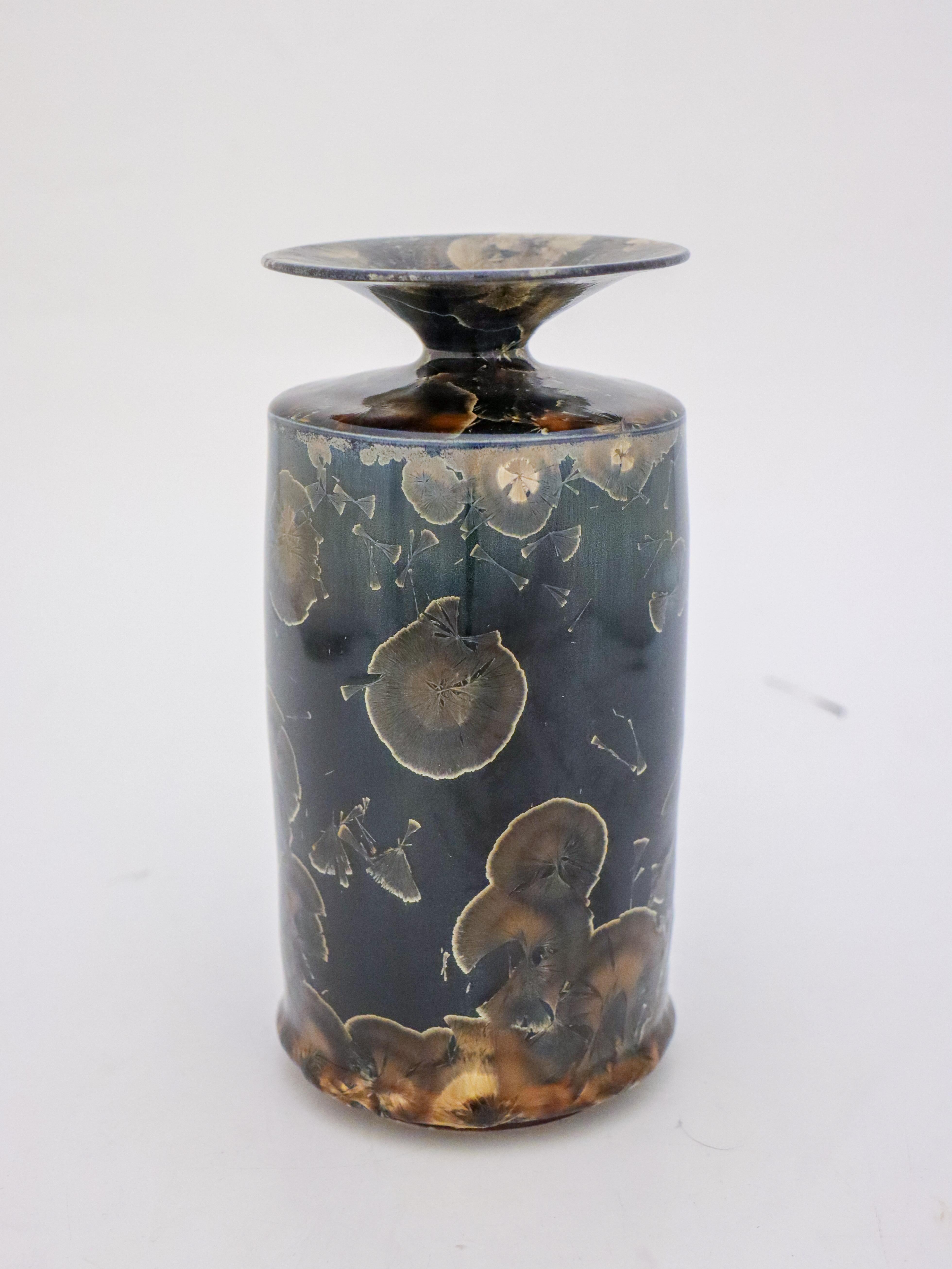 A unique vase in a dark blue color with a brown/silver crystalline glaze created by the contemporary Swedish artist Isak Isaksson in his own studio. The vase is 20 cm (8