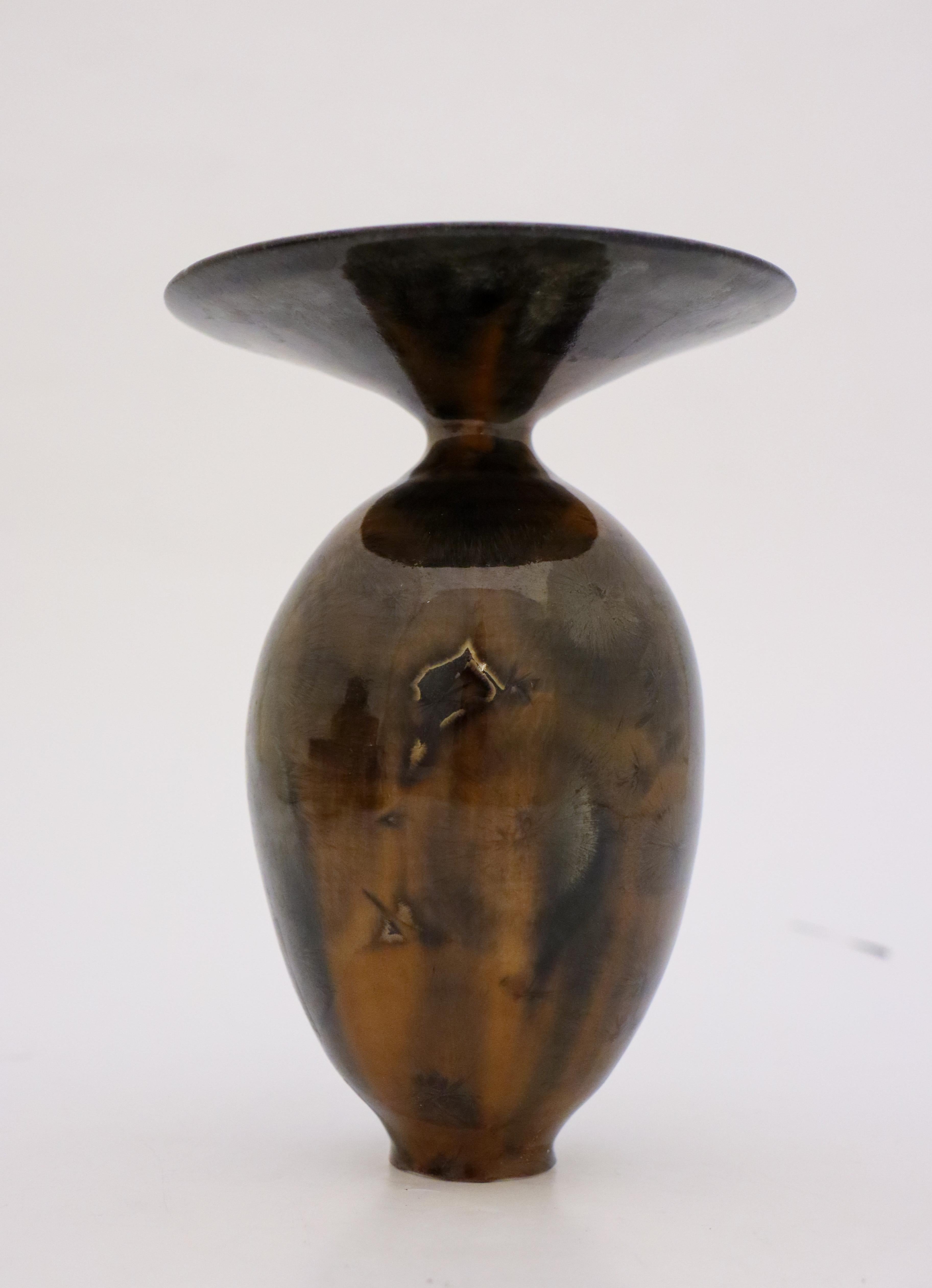 A unique vase in a dark brown color with a lighter brown crystalline glaze created by the contemporary Swedish artist Isak Isaksson in his own studio. The vase is 16 cm (6.4