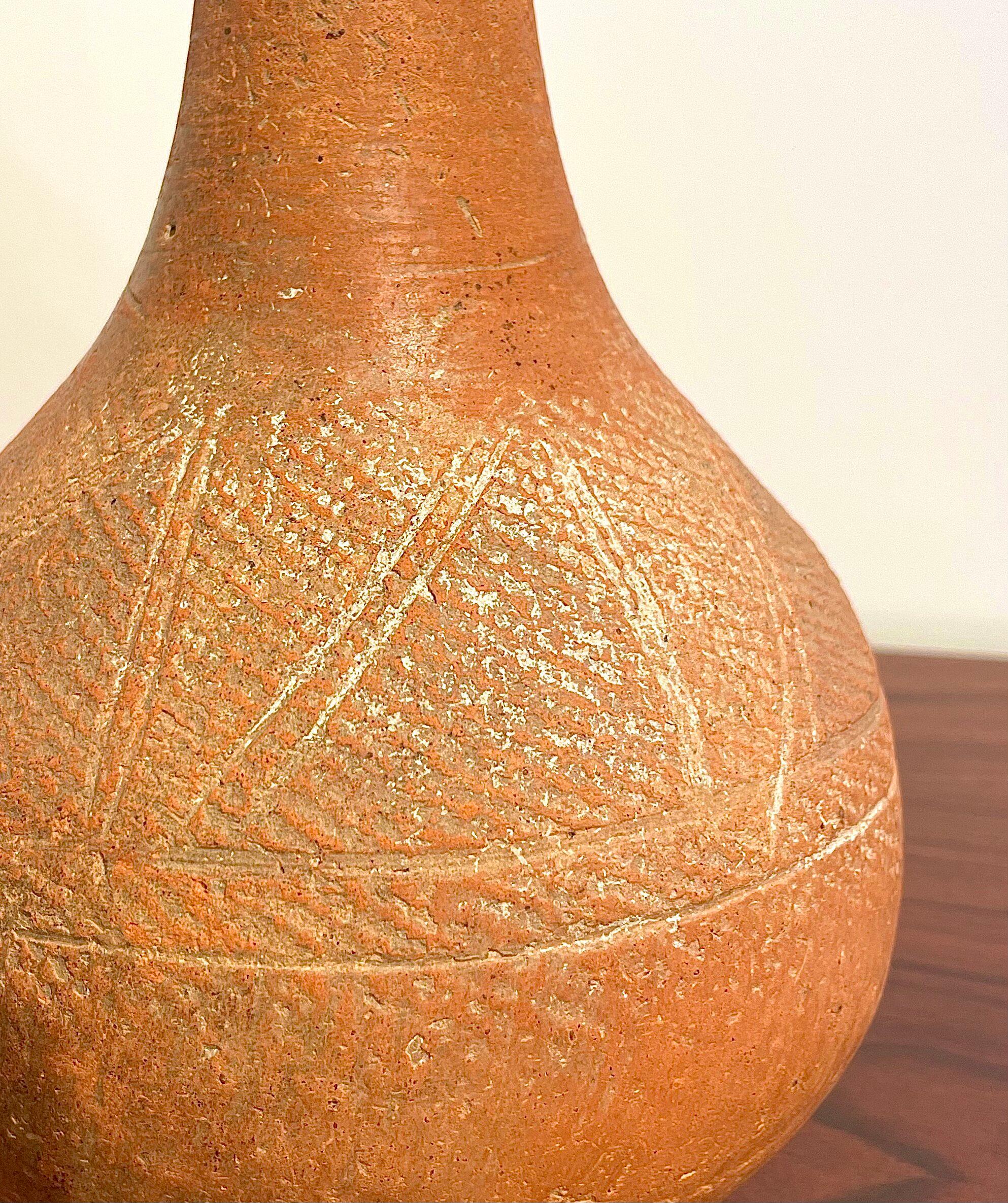 Peut-être 15e-17e s. objet de fouille du Niger (Afrique), belle engobe en argile rouge avec bandes incisées, col haut se terminant par une lèvre évasée, bel exemplaire. 
Bel objet décoratif et ethnique.